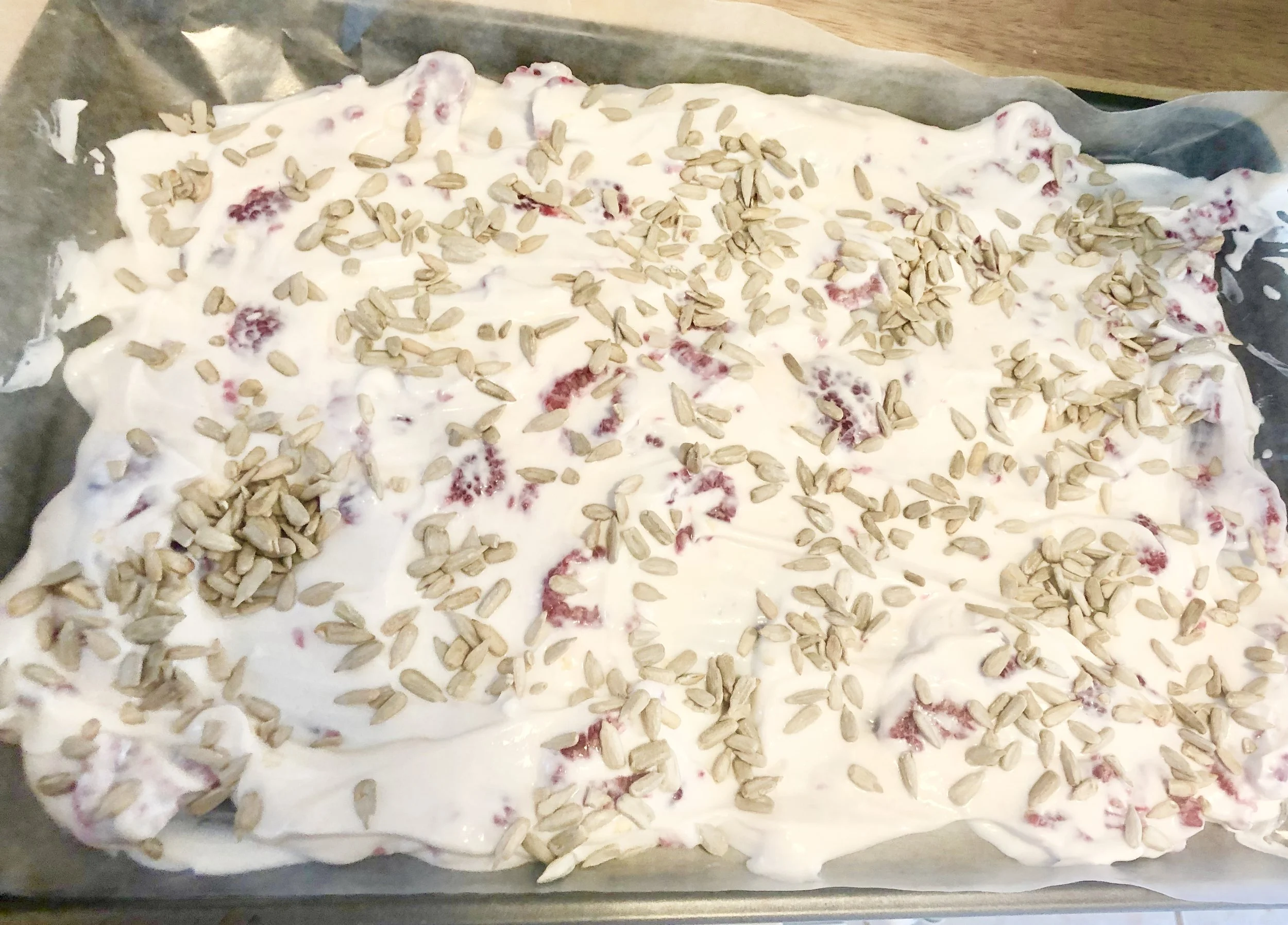 Spread the yogurt mixture over the wax paper/parchment paper with your spatula and then sprinkle your very liberal hand, the sunflower seeds over the top. Place in the freezer for 3-5 hours or until the bark is hard and able to be cut into squares. Caution! Melts quickly!