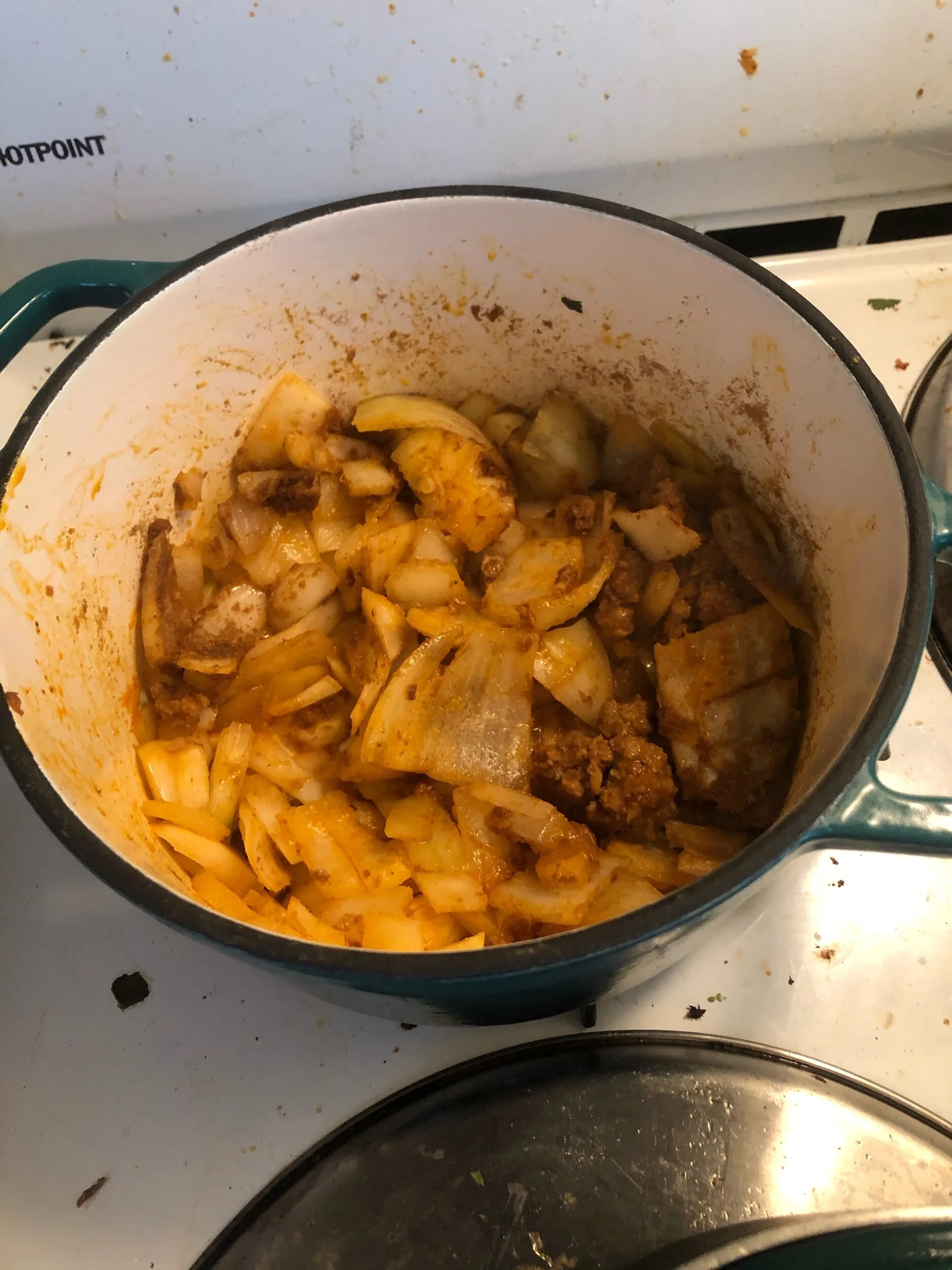 Remove the sausage from the heat using your slotted spoon and place to the siDe.  Add the onions, garlic and spices to the poT and cook on medium low in the sausage drippings until the onions are aromatic and clear.