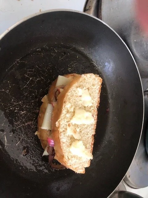 Place the sandwich, unbuttered bottom side down, in the same pan and cook on medium low. When it has browned, turn the sandwich over and keep it browning until the cheese has melted.