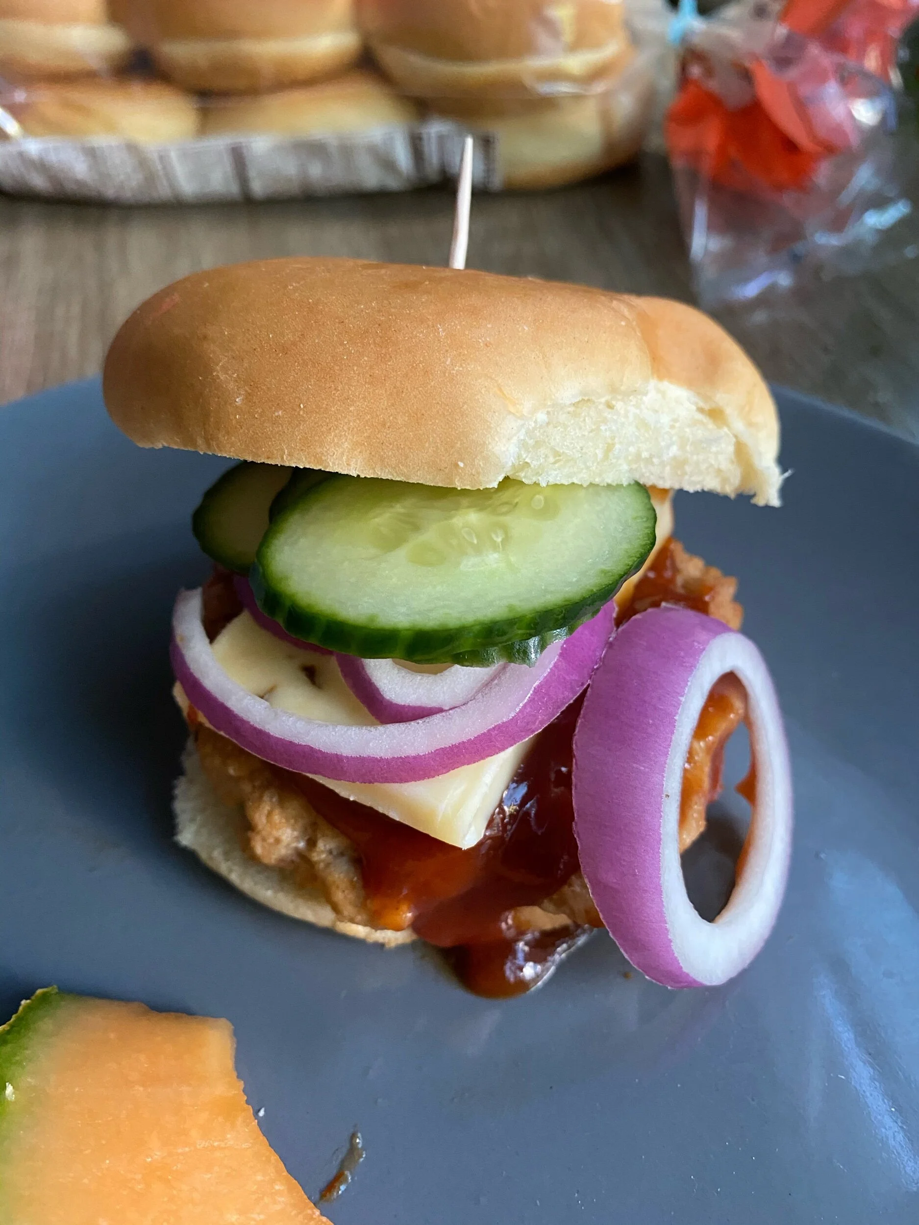 Serving suggestion - fruit as your side, burger garnished with quick pickles, onions, cheese and more sauce