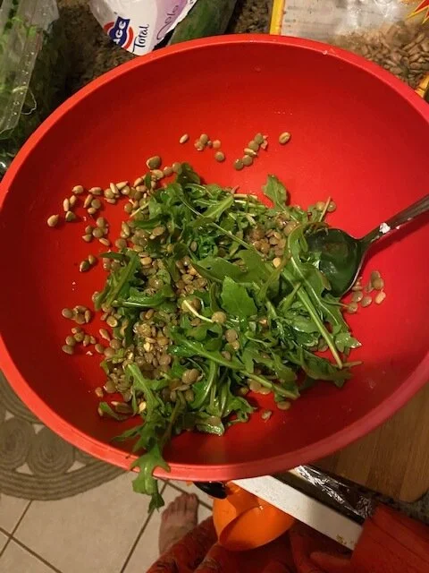 Drain the lentils, rinse, and cool. Add the lentils to your medium mixing bowl, and add the arugula, and lemon juice.  Serve over a bed of garlic with slices of ripe avocado.