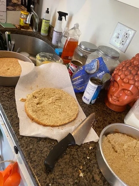 Assemble the layer cake in a pan: Cut each cake in half horizontally. Place one layer in the bottom of a 9-inch cake pan, moisten the top with 2 to 3 tablespoons simple syrup and spread 1/2 cup of the coconut filling in a thin, even layer with an of…