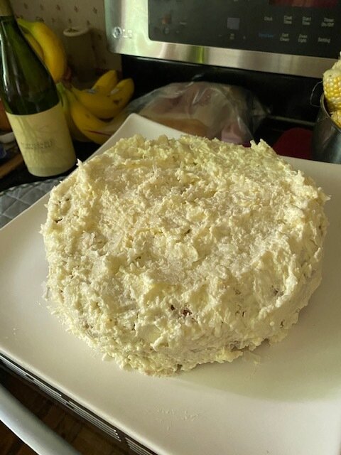 Make the icing: Whip the cream with the confectioners’ sugar and coconut extract until stiff peaks form. Spread on the top and sides of the cake and sprinkle with toasted coconut. Refrigerate until ready to serve.