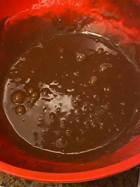 Pour the hot cream over the diced chocolate and whisk as it melts into smooth liquid.   Add the liquid into a sm baking dish and refrigerate until the ganache is hard and cool to the touch - the consistency of modeling clay.