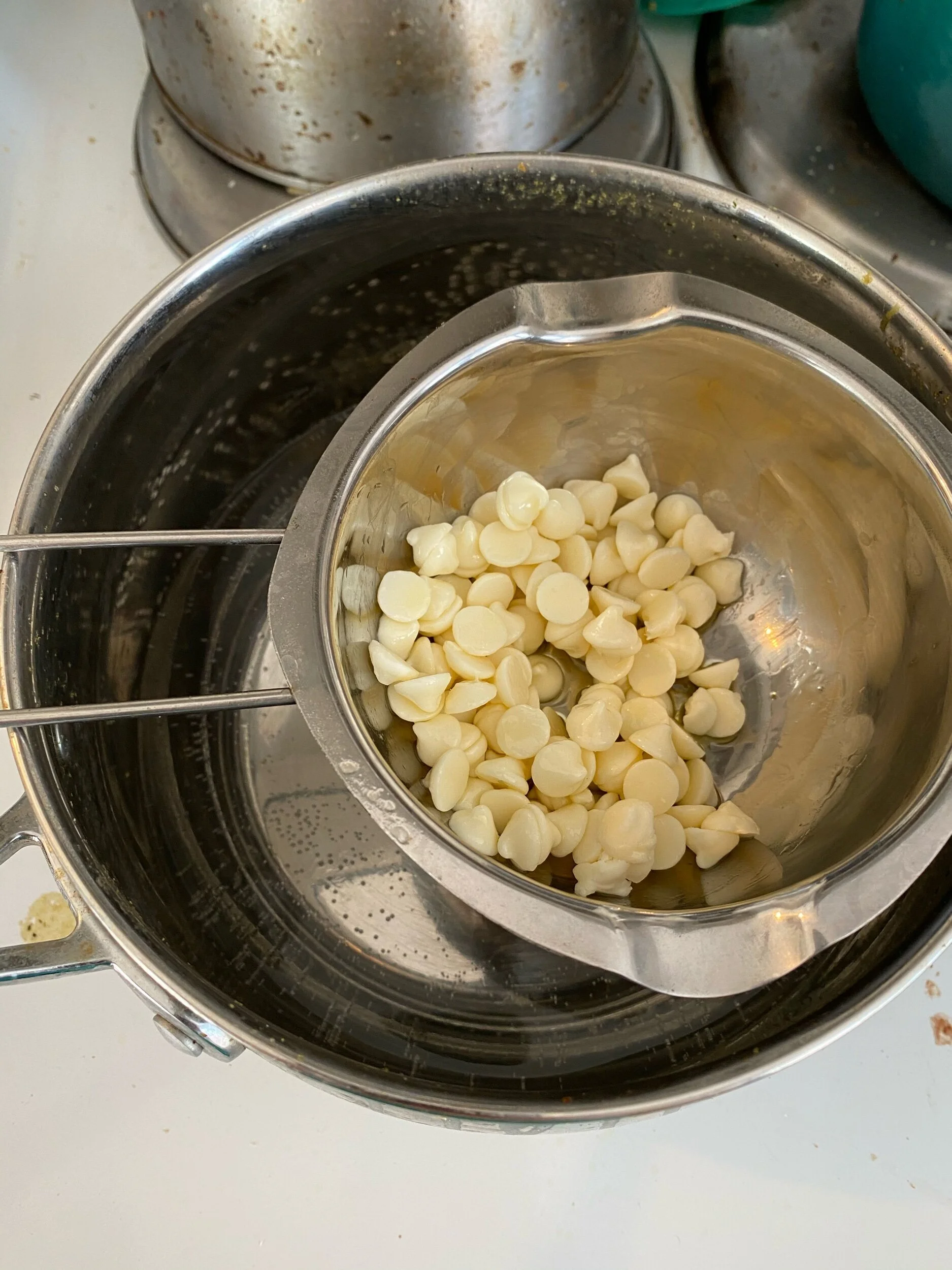 White chocoLate melt: add 2 inches (or so) of water to your mediuM saucepan and place either a double boiler (pictured) or glass bowl over tHe top. Turn up so water boils and add your chips. Using a heat resistant spatula (silicone) keep stirring th…
