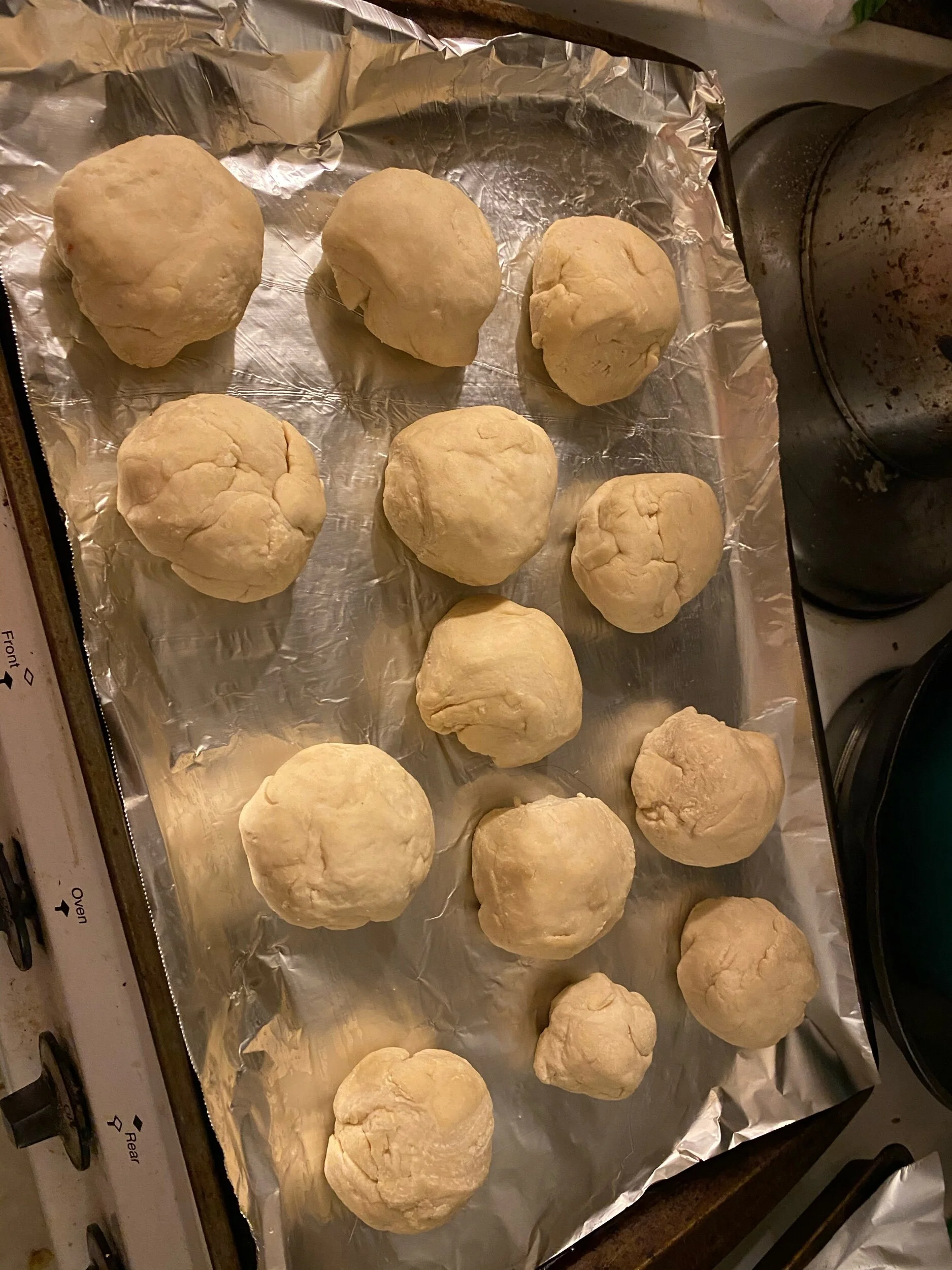 After it has risen, but into a dizen or so (I made a bakers dozen because 13 is such a lucky number) pieces of dough using whatever you have on hand. If you’re like me you don’t have what the NY Times thinks home bakers have, so I used a knife. Take…