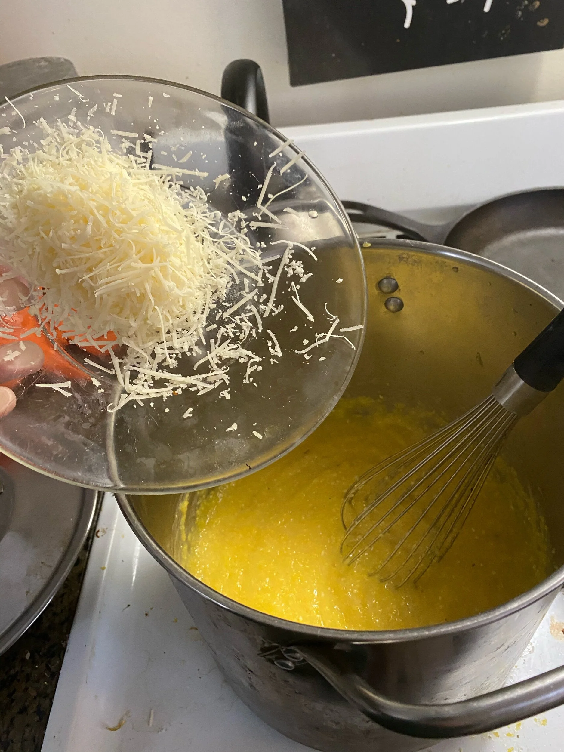 Remove the heat and mix in 1 cup of grated Parmesan.  Keep whisking so it does not clump up and integrates completely. You can’t wait for it to cool too much ; you need the cheese to seamlessly integrate into the polenta.