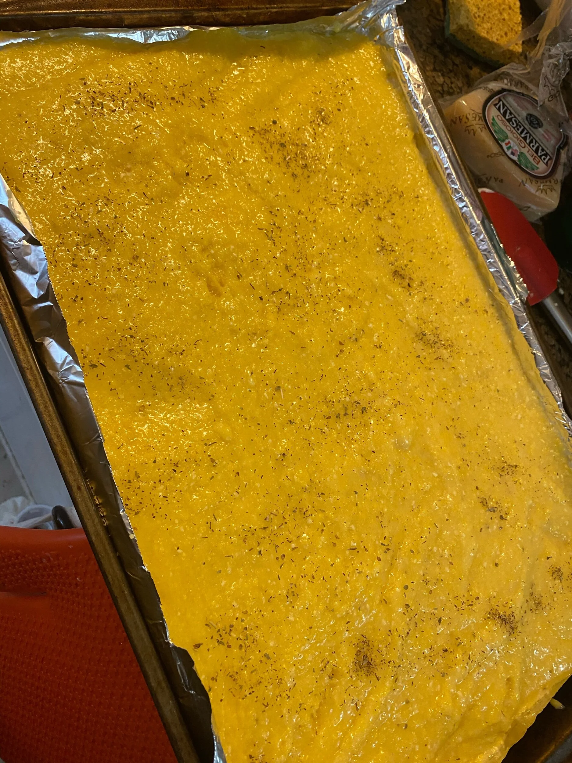 Pour the polenta into your baking sheet to cool. Season with salt, pepper, and powdered garlic.