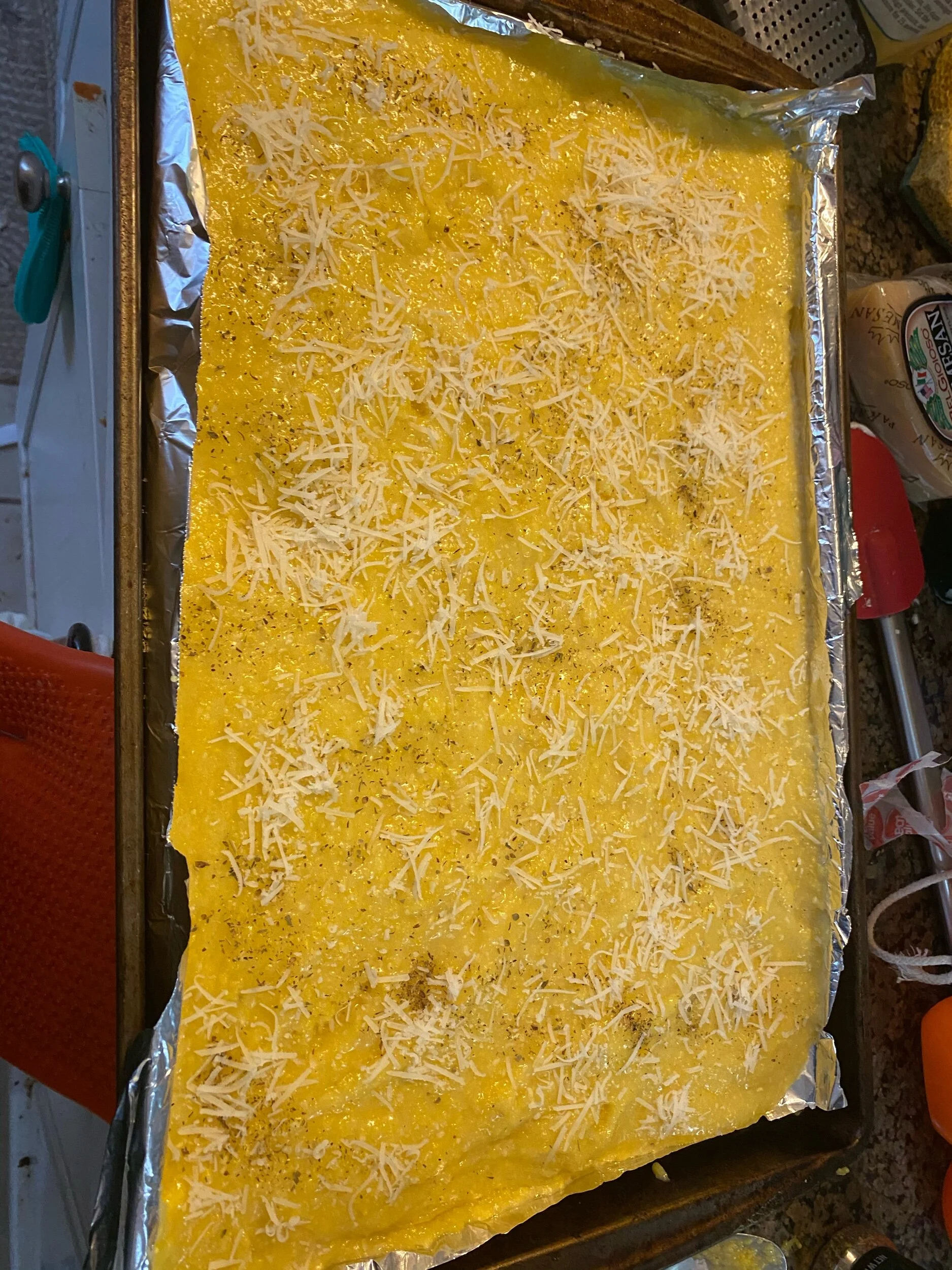 Cover the polenta sheet with 0.5 cup of shredded parmesan. Bake in the oven for 13-18 minutes. Remove from the oven and cool. The cooling part is the most important part of the whole dish because if you remove the polenta from the pan when it’s hot …