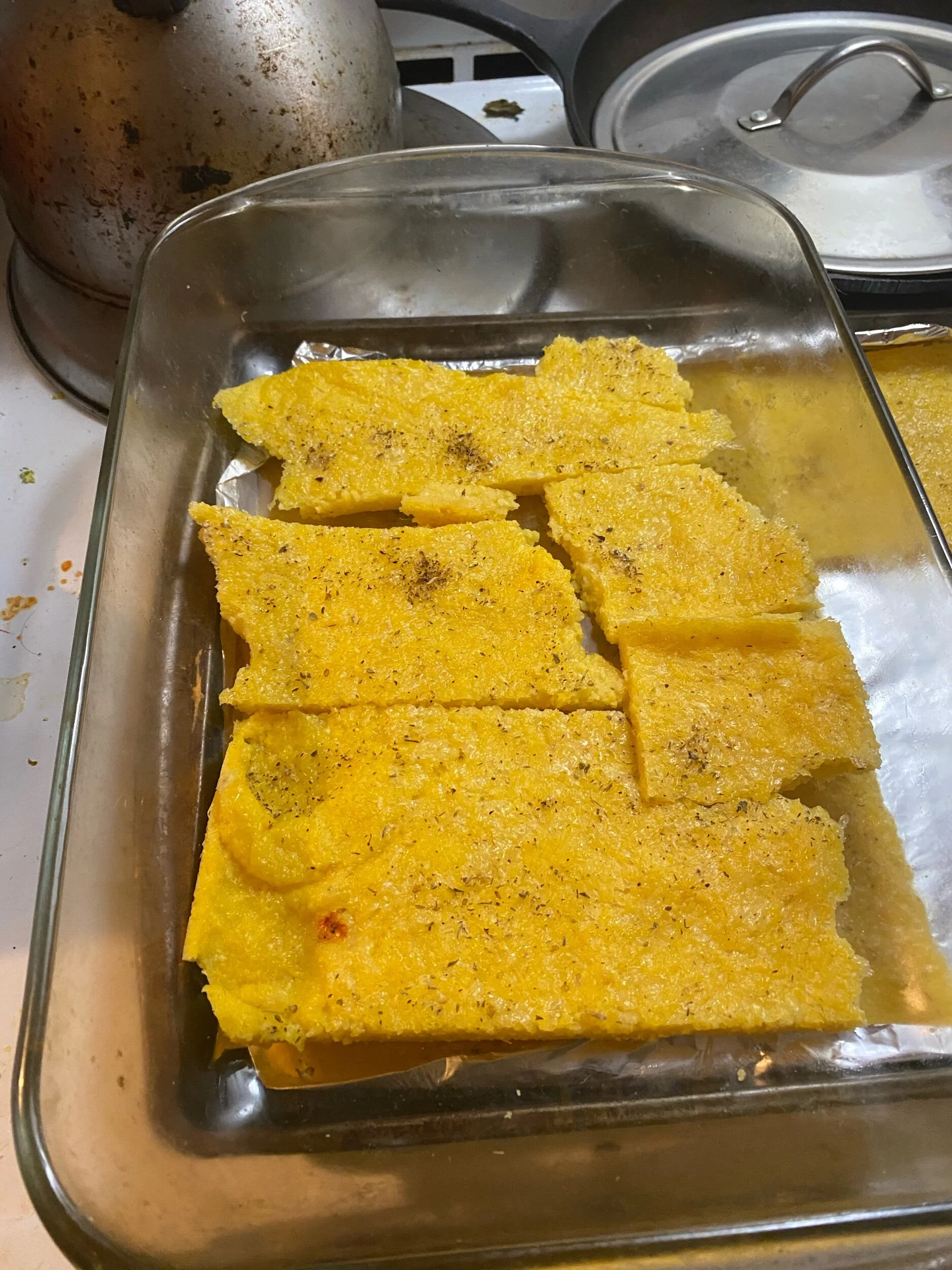 Cut the polenta into strips. Place a layer of polenta on the bottom.