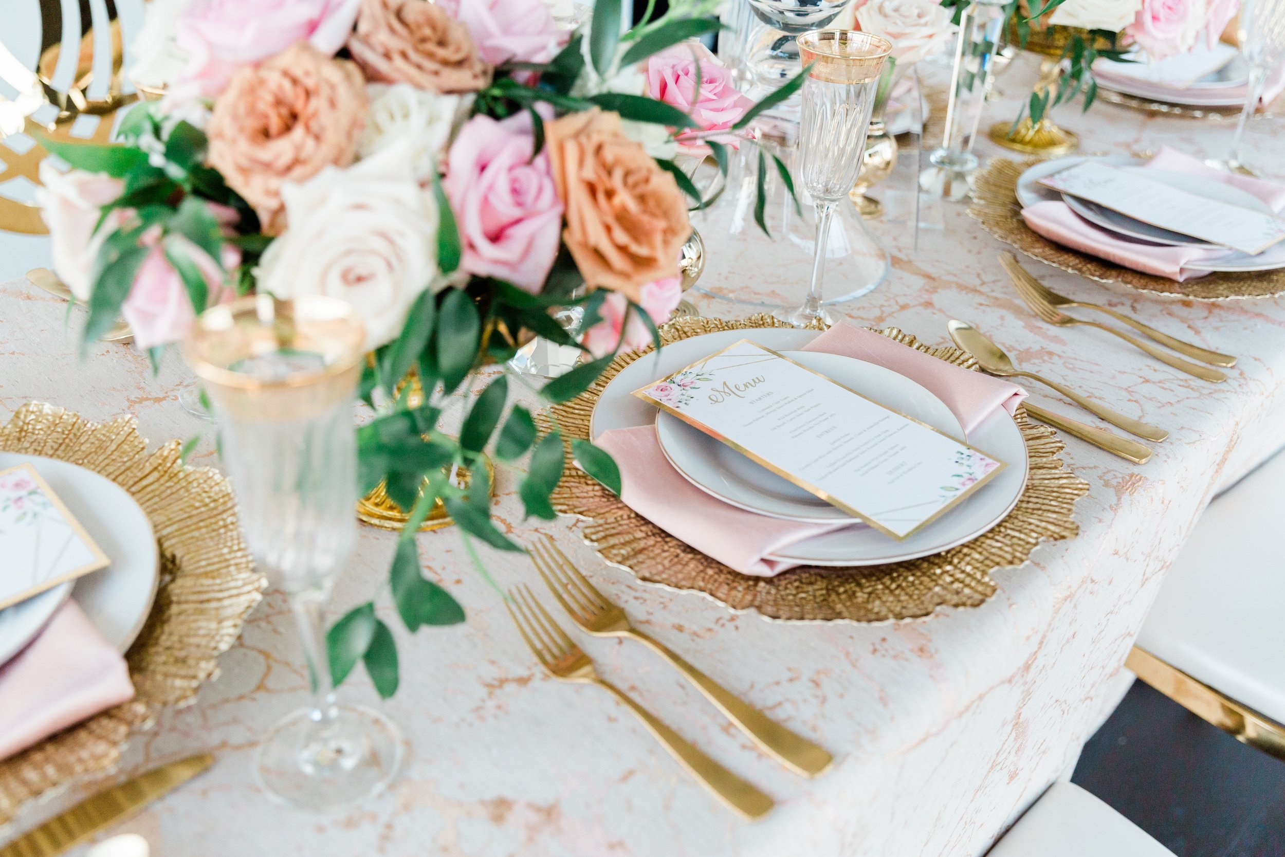 Tablescape with gold accents, blush linen, and roses