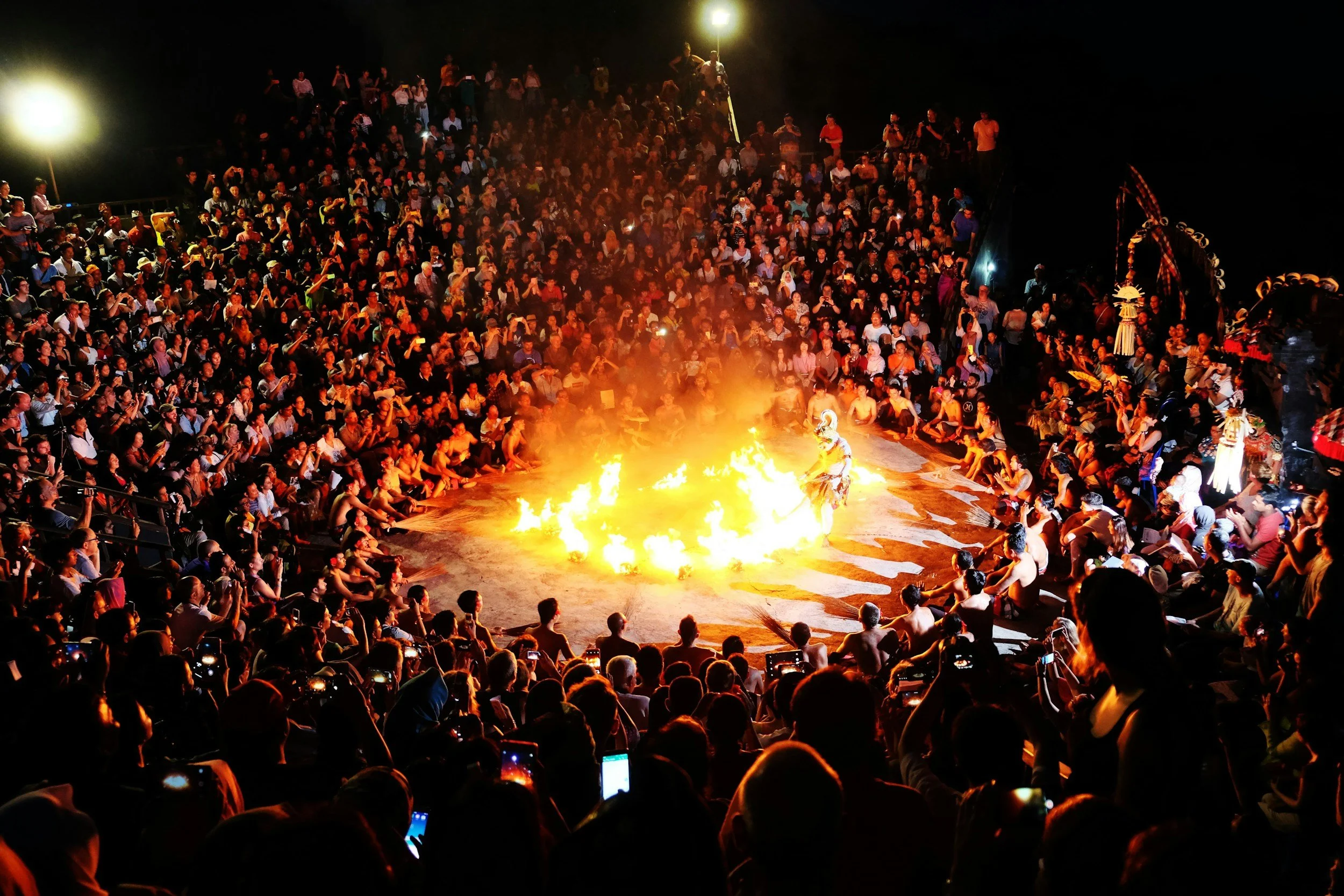 Kecak fire dance performers chanting in a circle at Uluwatu Temple, Bali, at sunset