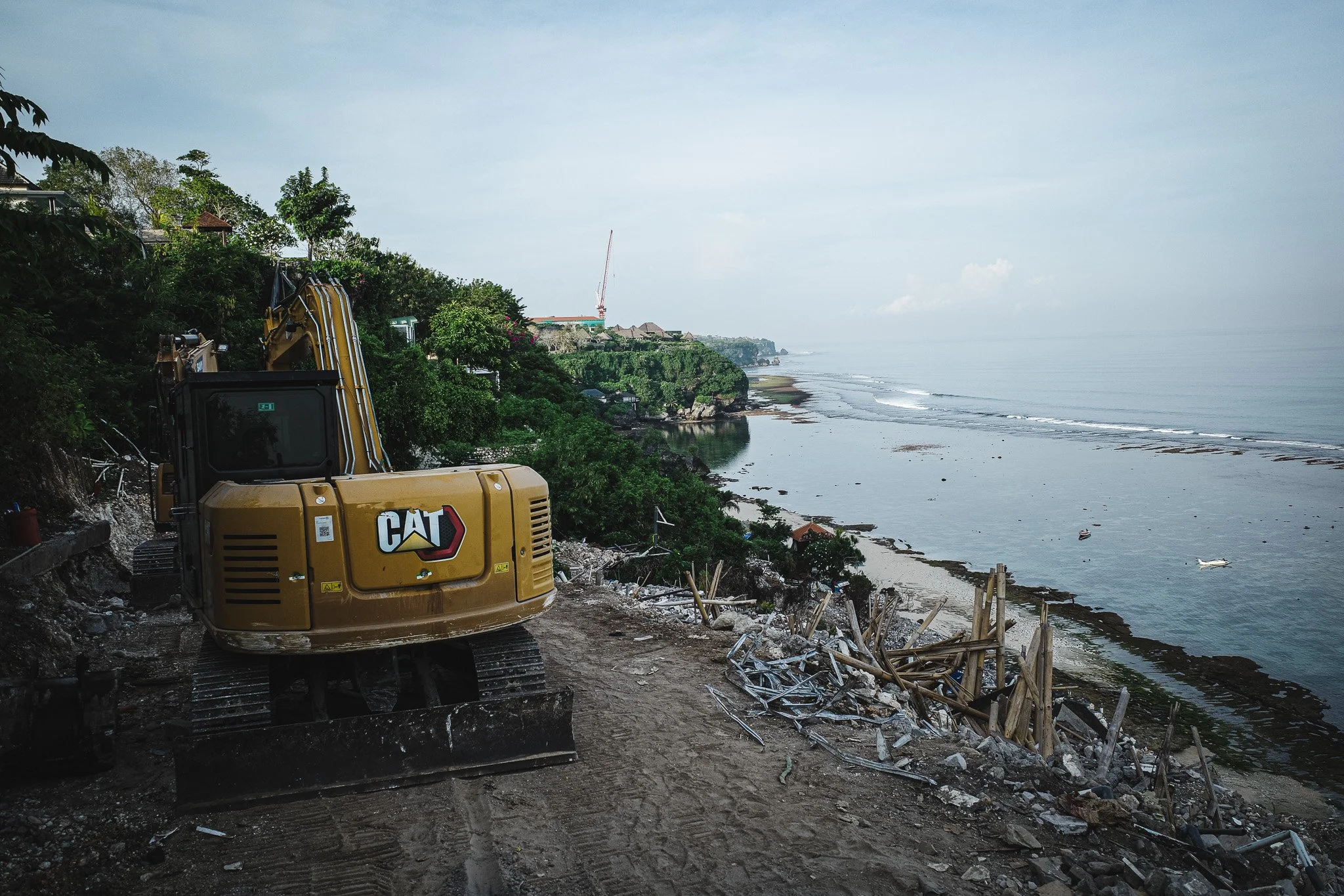 Excavator demolishing cliff-side warungs at Bingin Beach, Bali