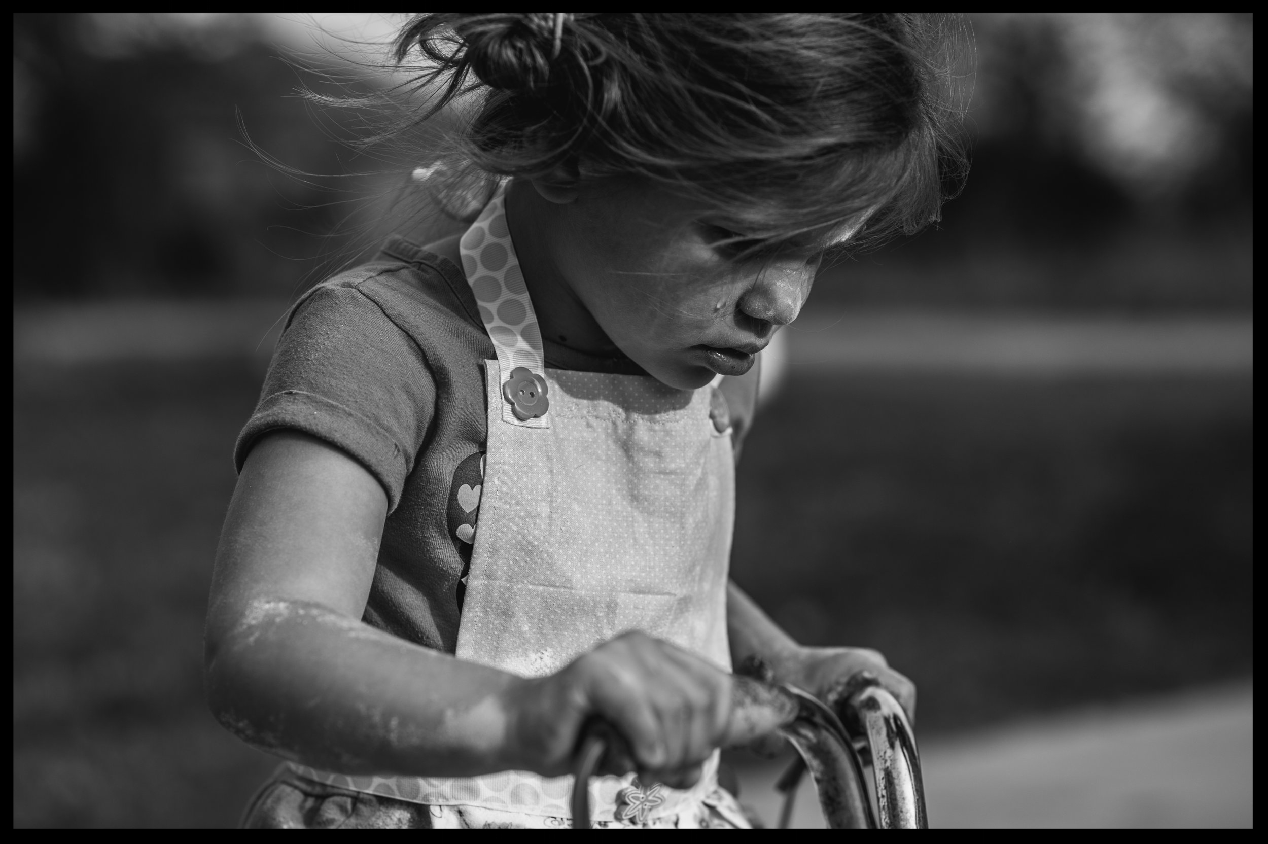Little girl on a bike crying, black and white