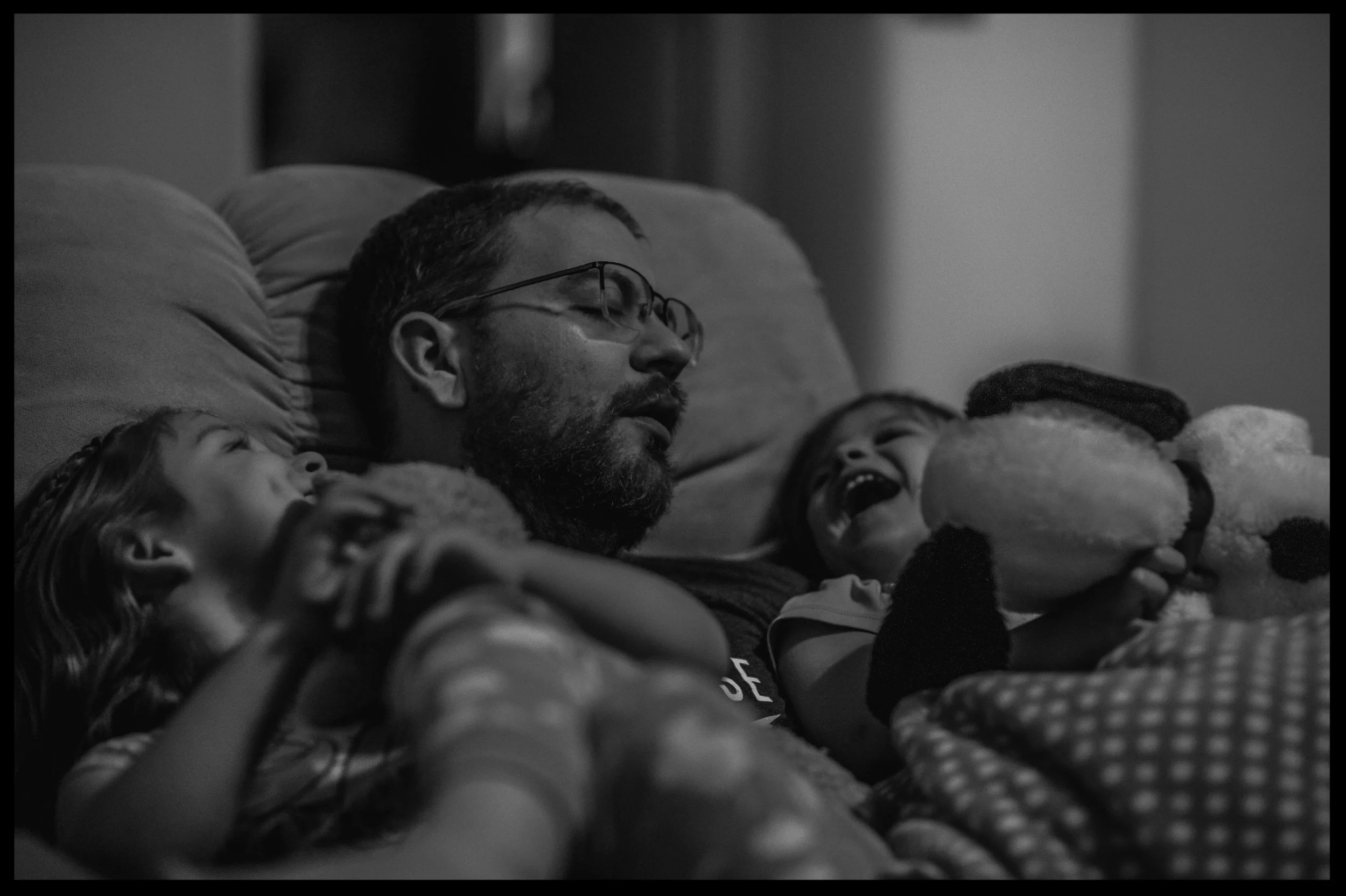 Daddy being silly in the recliner with his two daughters