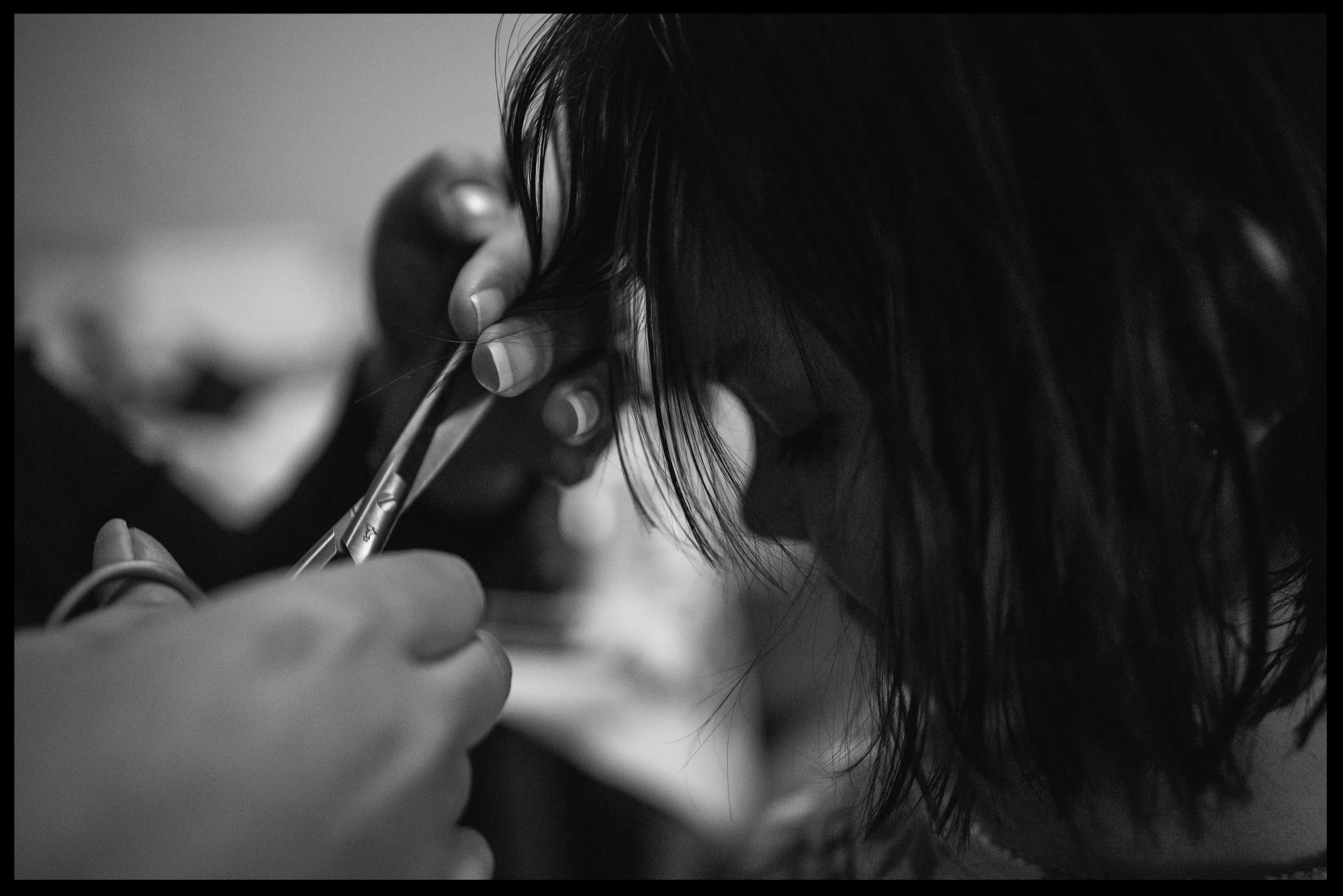 Mother cutting her daughter's hair