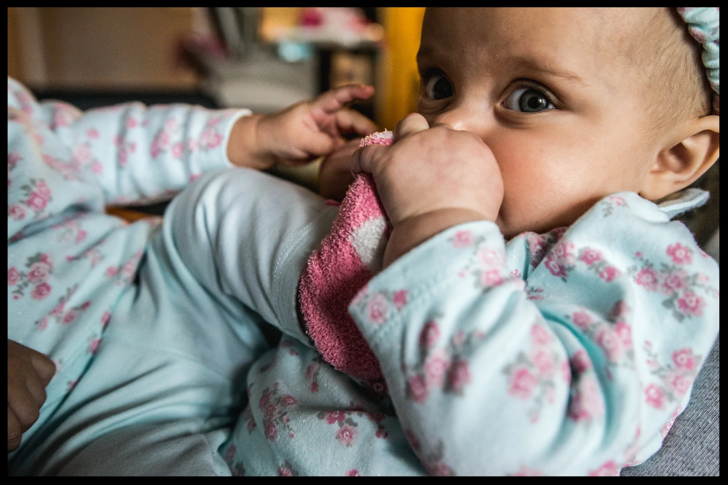 Baby girl chewing on her twin sister's foot, color, Aurora, Colorado