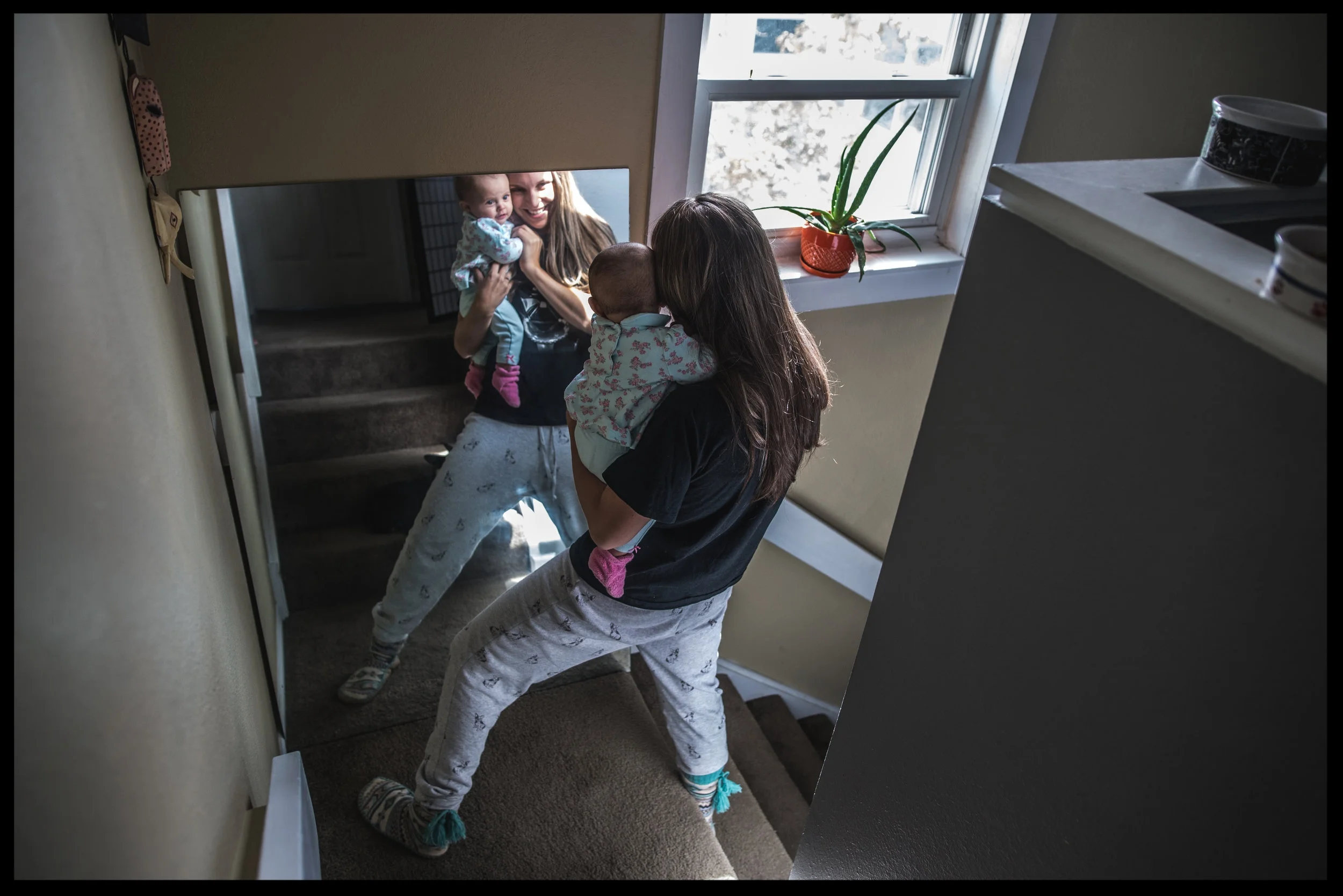 Mother holding her baby girl and looking in the mirror, color, Aurora, Colorado