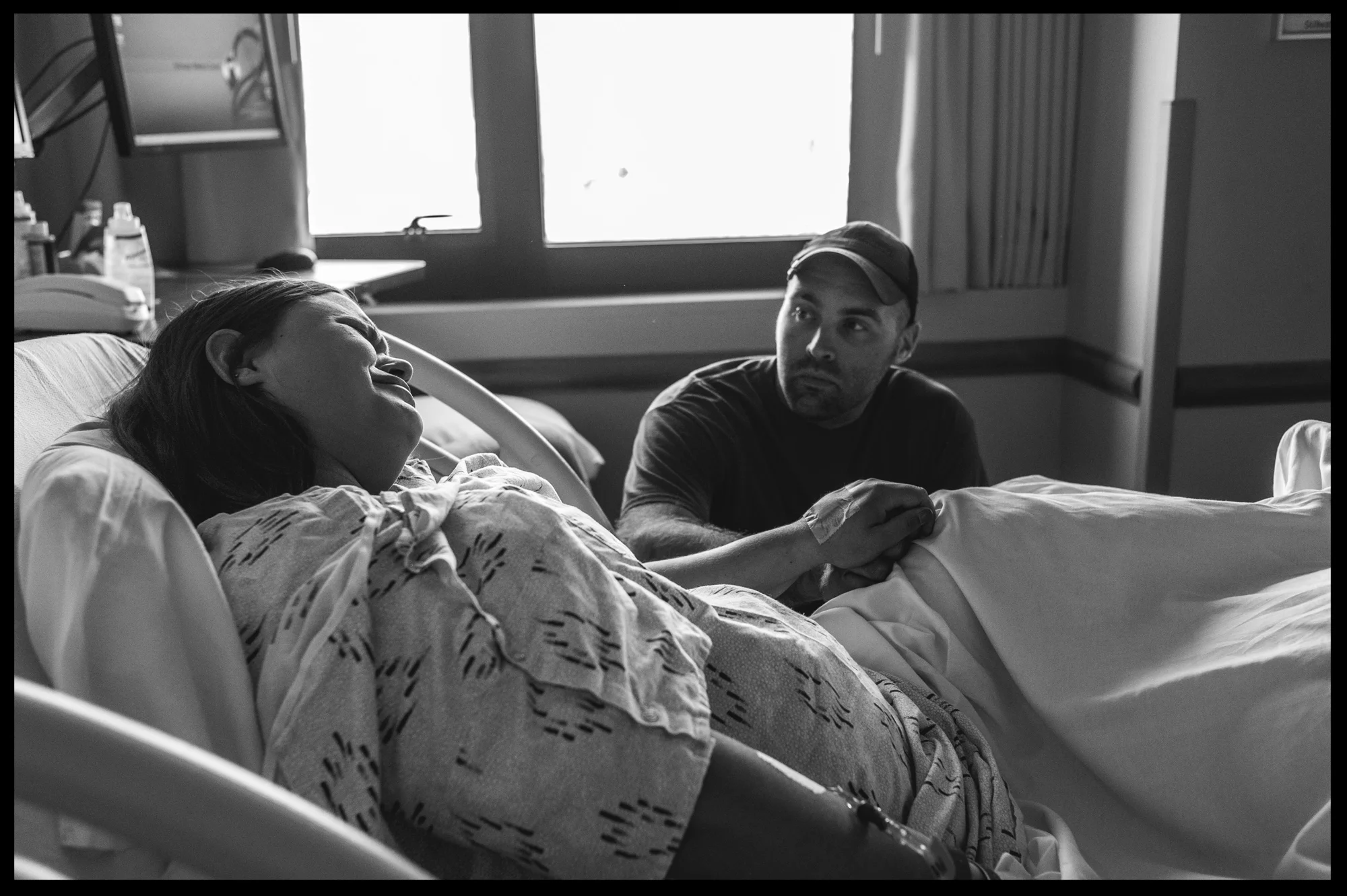 Husband holding the hand of his wife in labor, black and white, Stillwater, OK