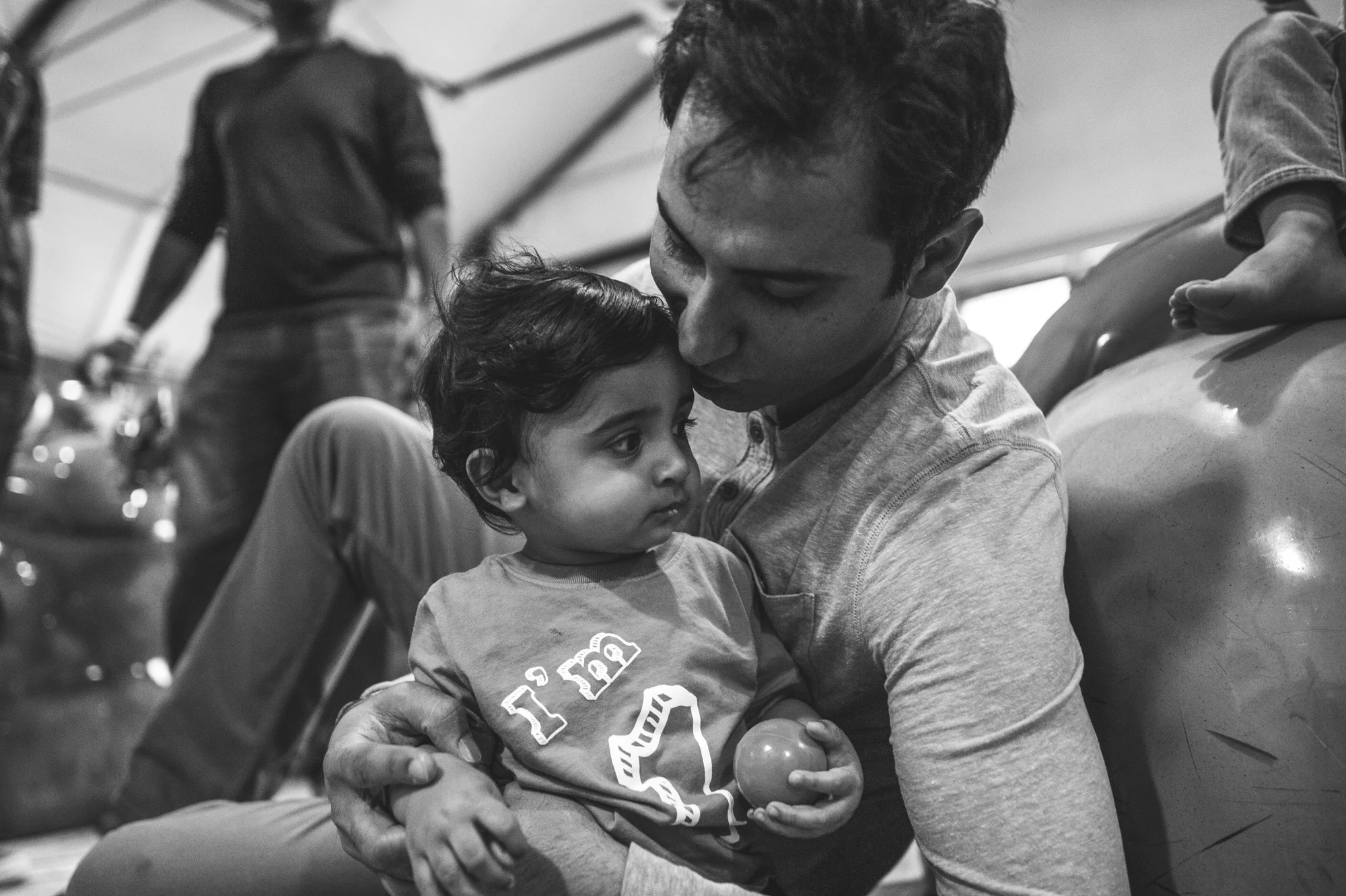 Father kisses his baby boy on his first birthday, black and white