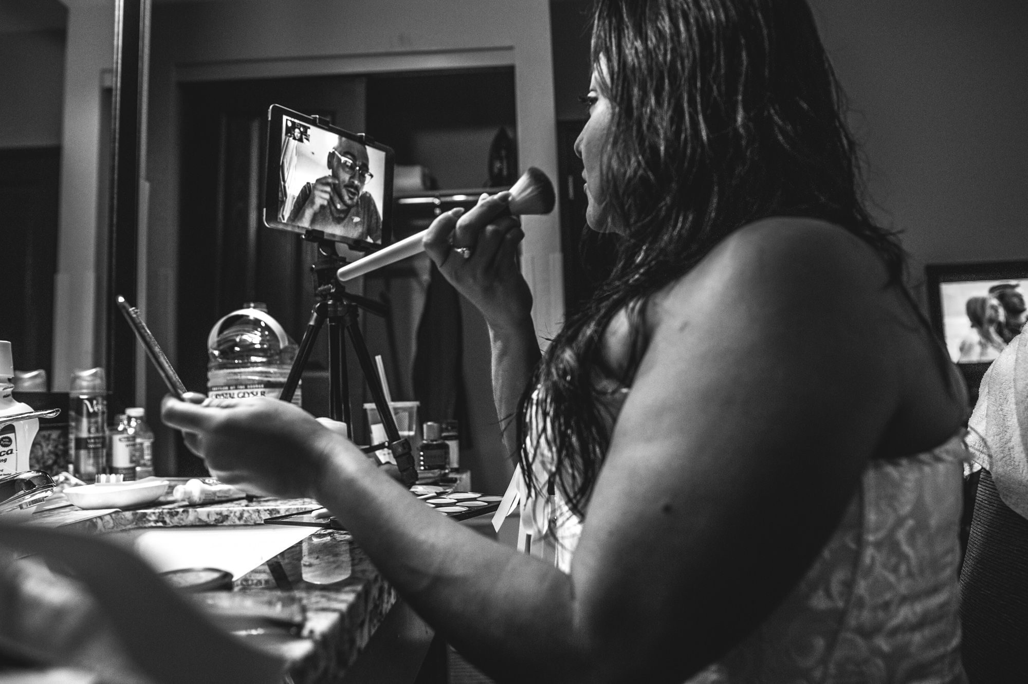 Bride puts on her makeup for the wedding while her friend helps her via skype, Estes Park, Colorado, black and white