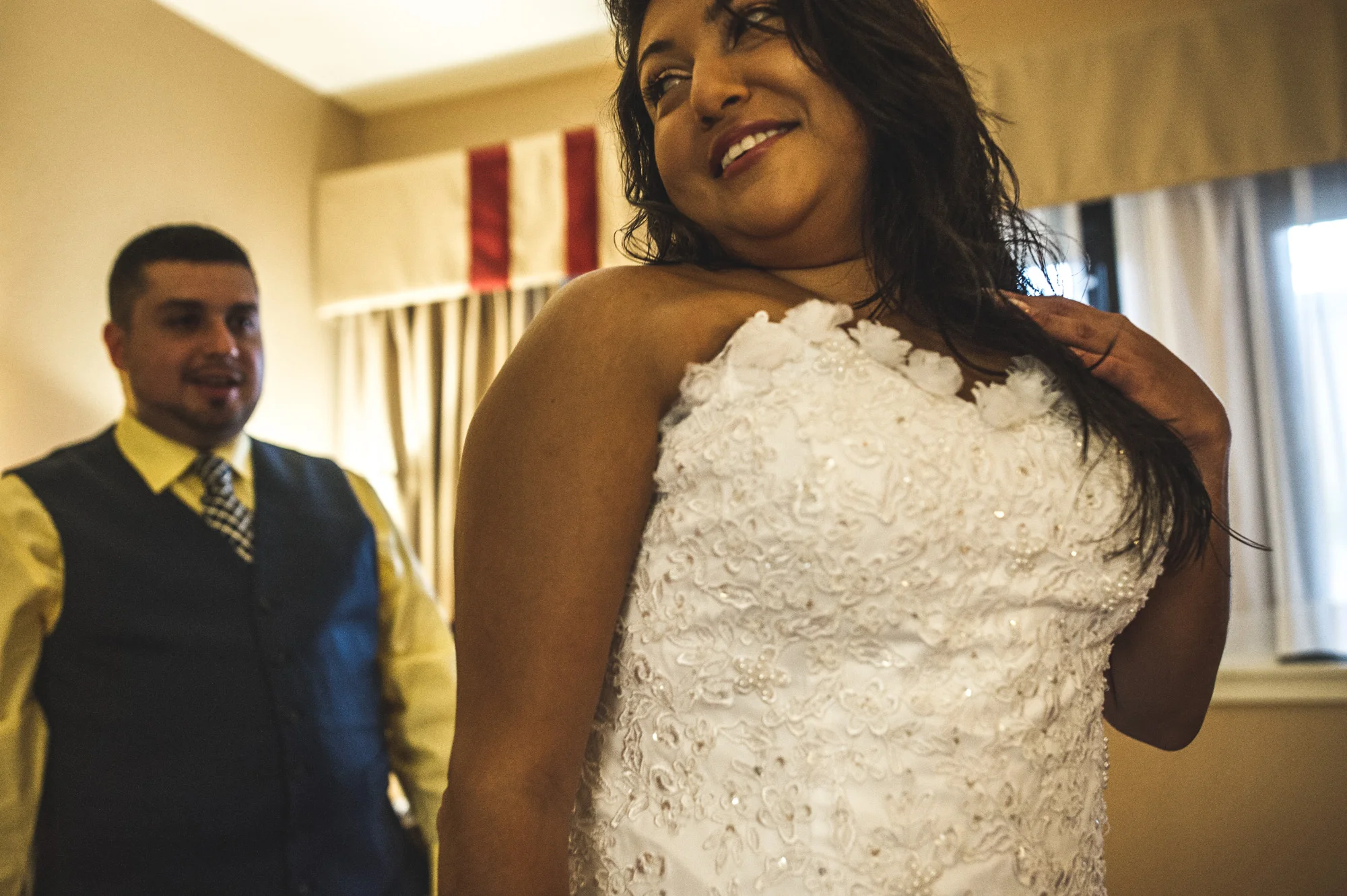 Groom looks at the back of his bride, whose dress he has just successfully tied for her, Estes Park, Colorado, color