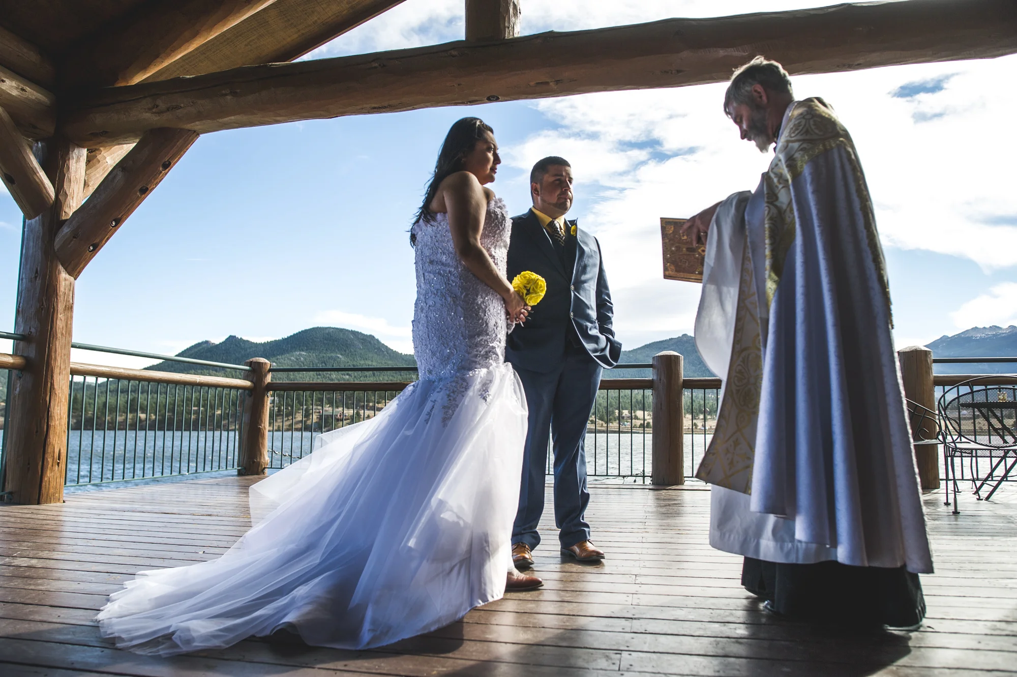 Bride and groom stand on a patio during their wedding ceremony at a resort in Estes Park, Colorado, color