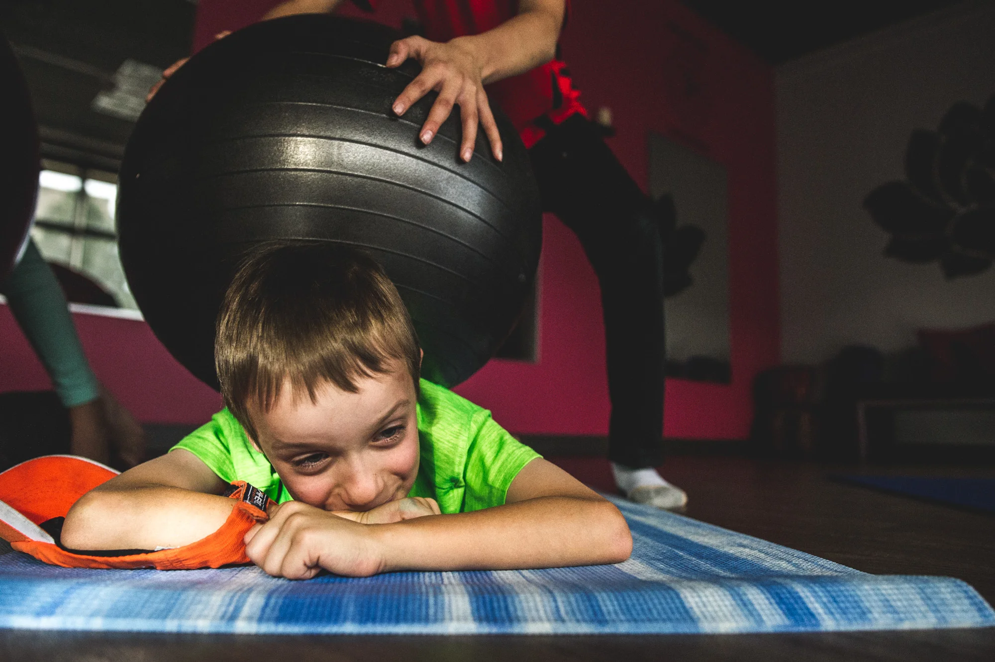 One student rolls a giant soft ball on another student's back during yoga class, Highland's Ranch, CO, color