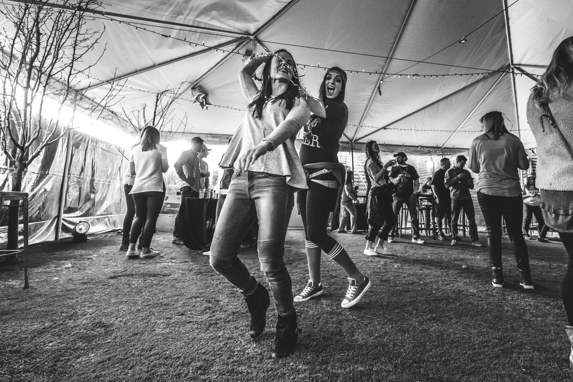 Black and white photo of two women dancing in a giant white tent during a charity event for the Autism Society of Colorado in Denve.