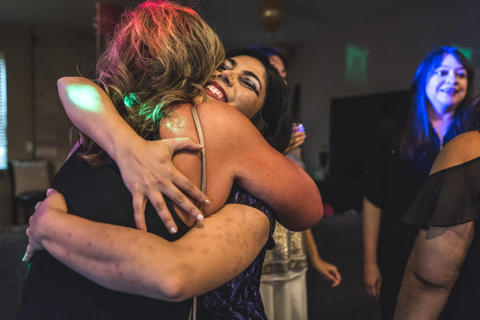 Two women embrace at a house party in Denver