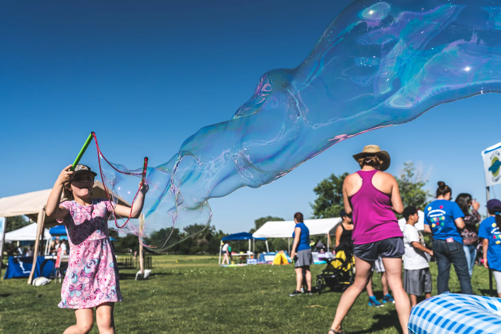 Little girl playing outside with giant bubbles
