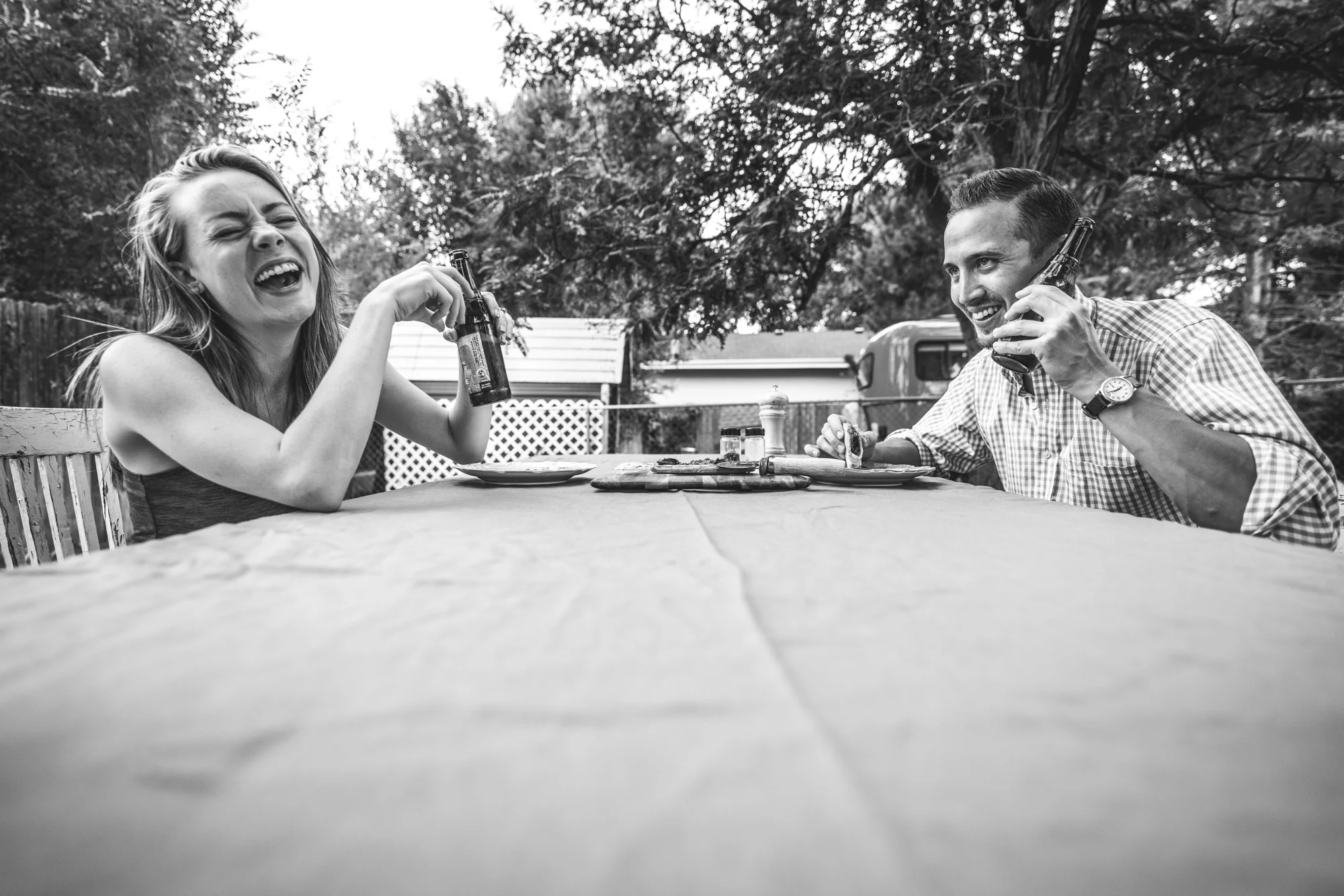 Man and woman at an outside table laughing