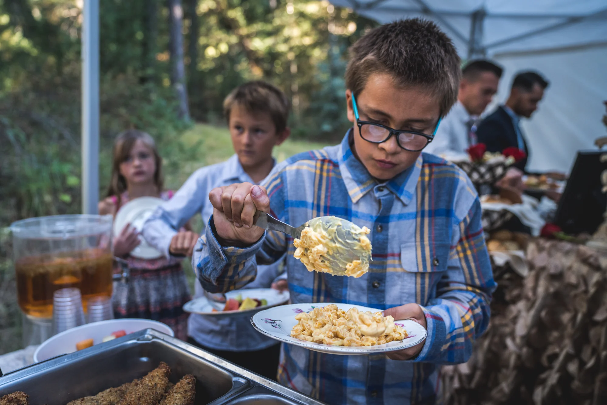 Kid at a wedding reception buffet gets a heaping helping of mac and cheese