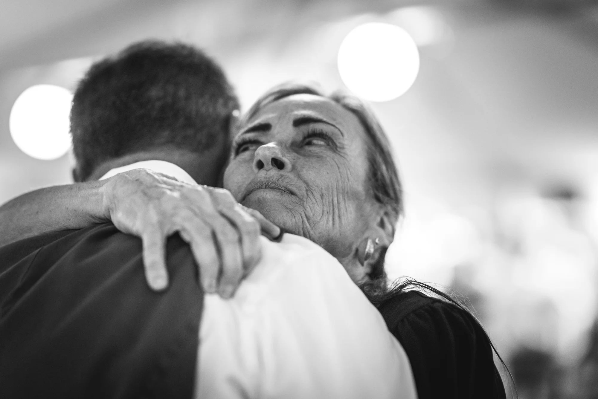 Mother hugs her son tight as they dance at his wedding