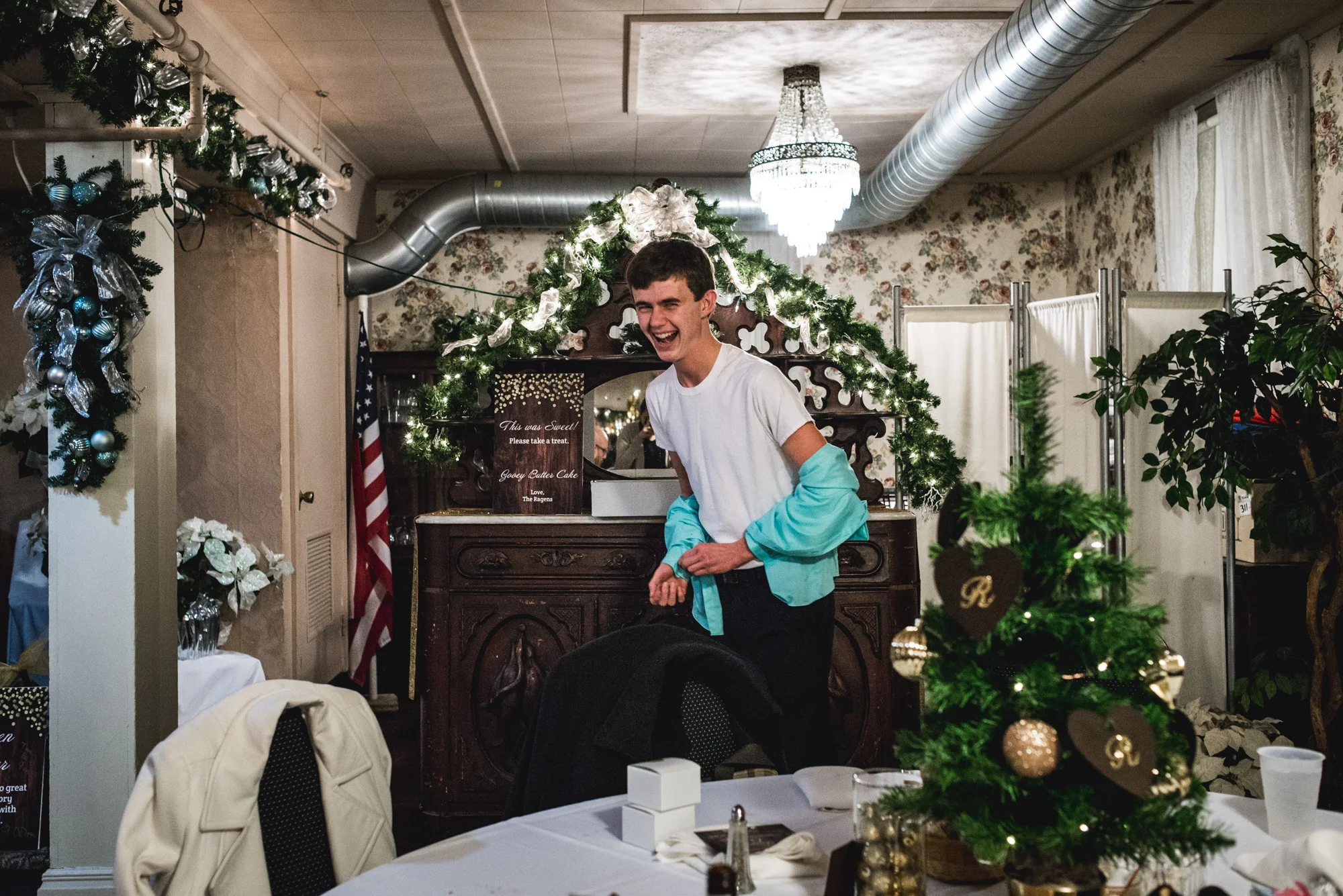 Man at a wedding takes off his button-down shirt and laughs