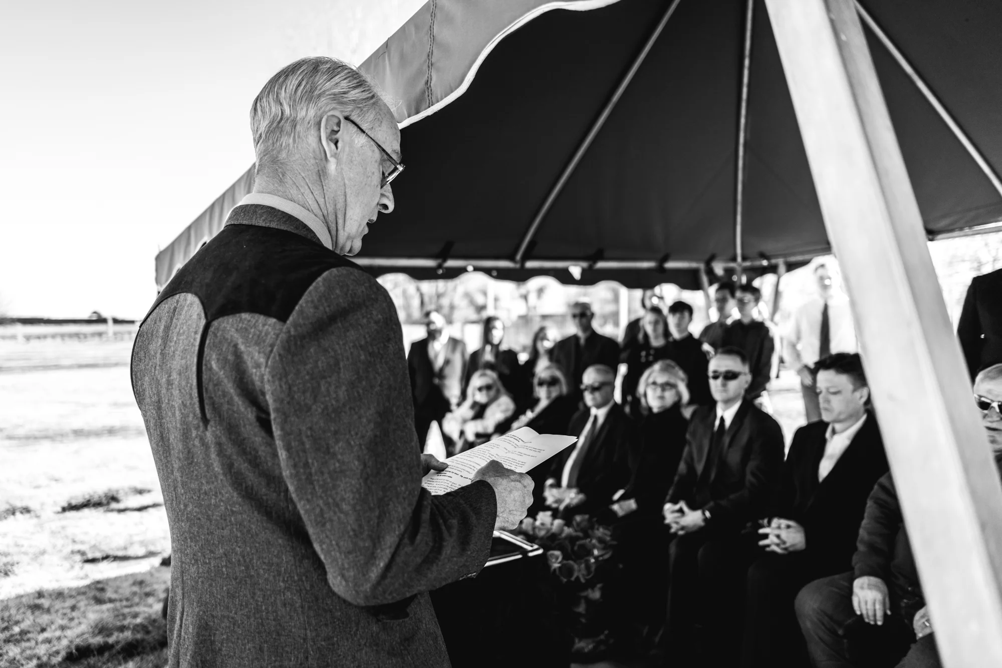 A man gives a eulogy under a tent during a memorial service in a cemetery in Greeley, Colorado