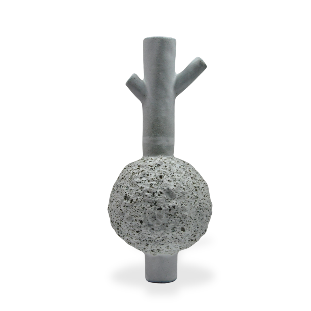 Six white porous volcanic rocks with black holes arranged in two columns on a white surface.