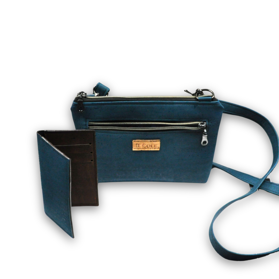 An orange and black leather handbag with multiple zippers, a matching wallet, and a decorative purple and gold tassel, all labeled 'T. COLE' against a white background.