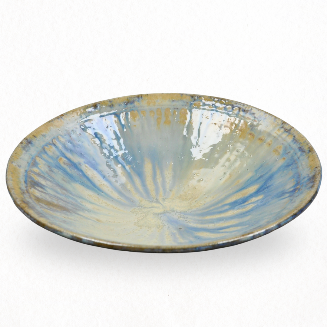 Empty ceramic plate with a scalloped edge and a textured light blue and yellow glaze.