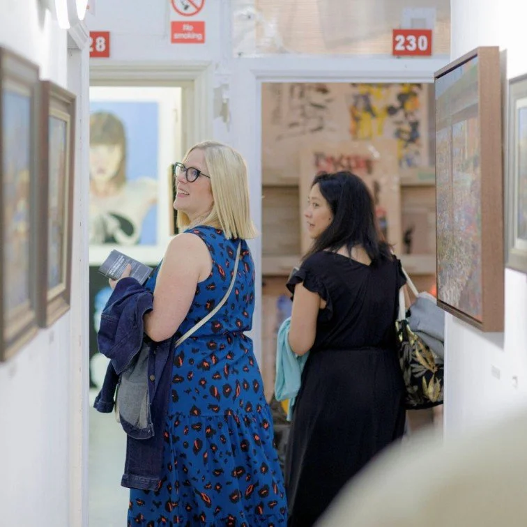 Visitors of the art fair walking down the corridors, surrounded by open doors of art studios