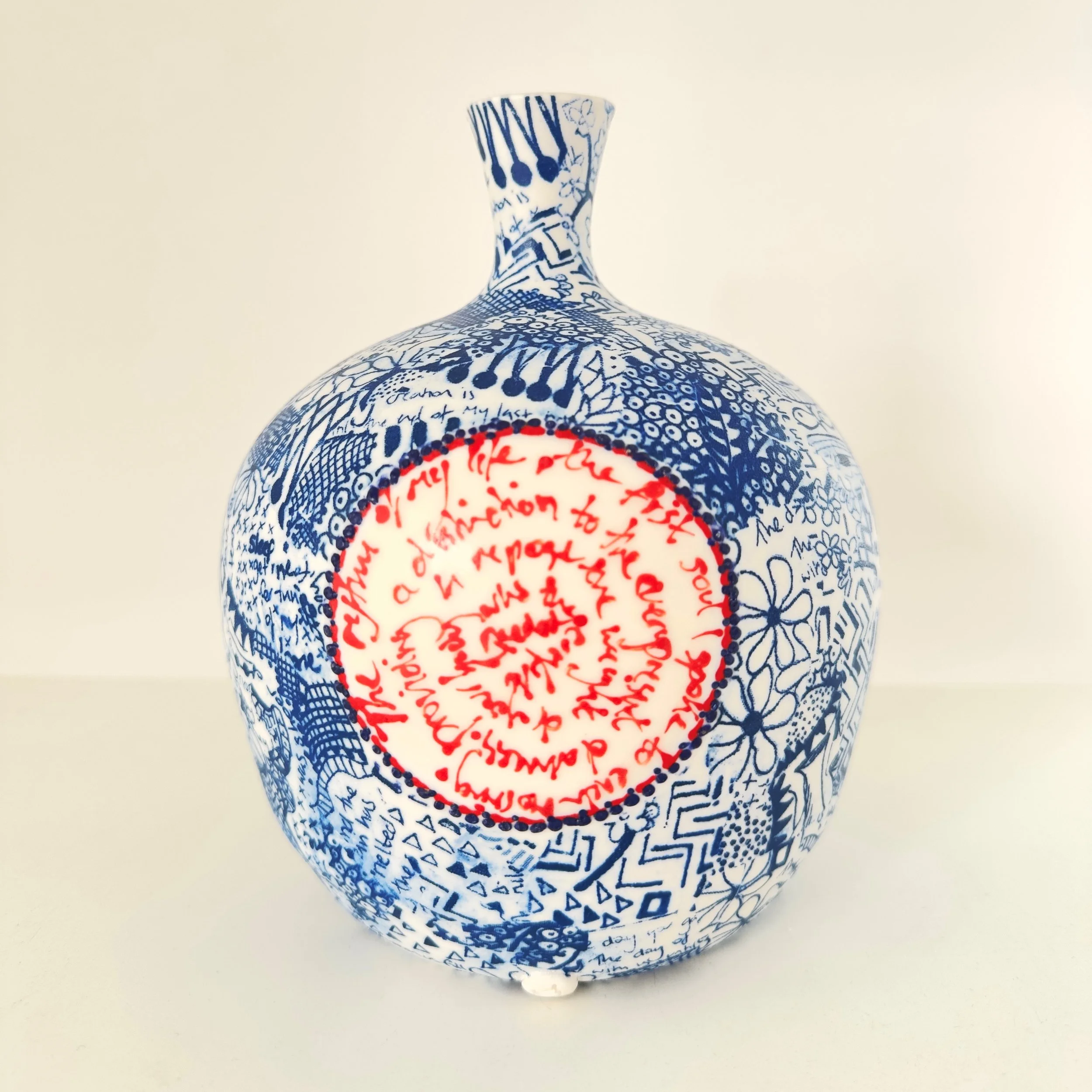 Three decorative ceramic vases with blue and white patterns and red interiors, placed on a white surface against a plain white background.