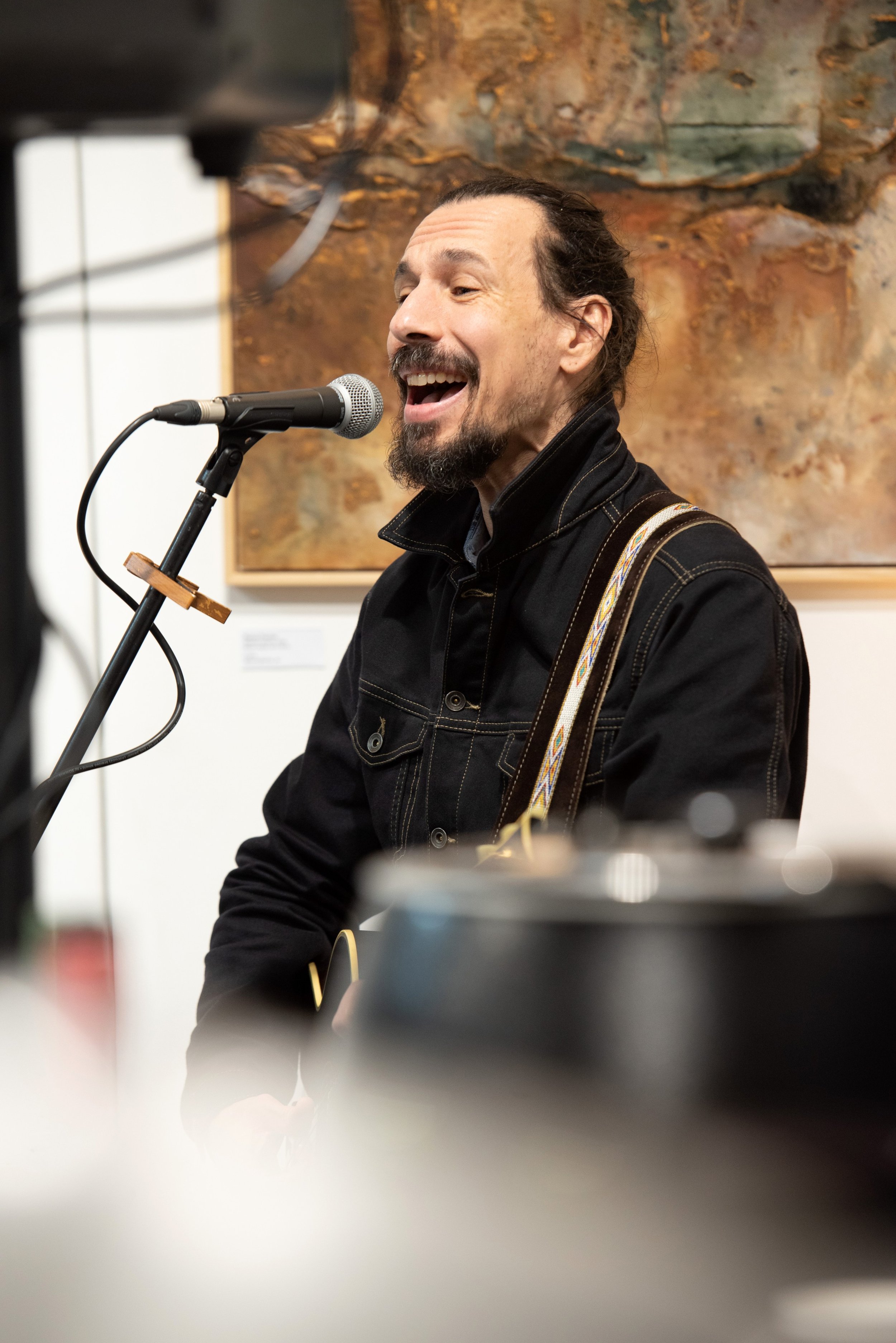 Musician playing the guitar and singing during the opening event of the art event
