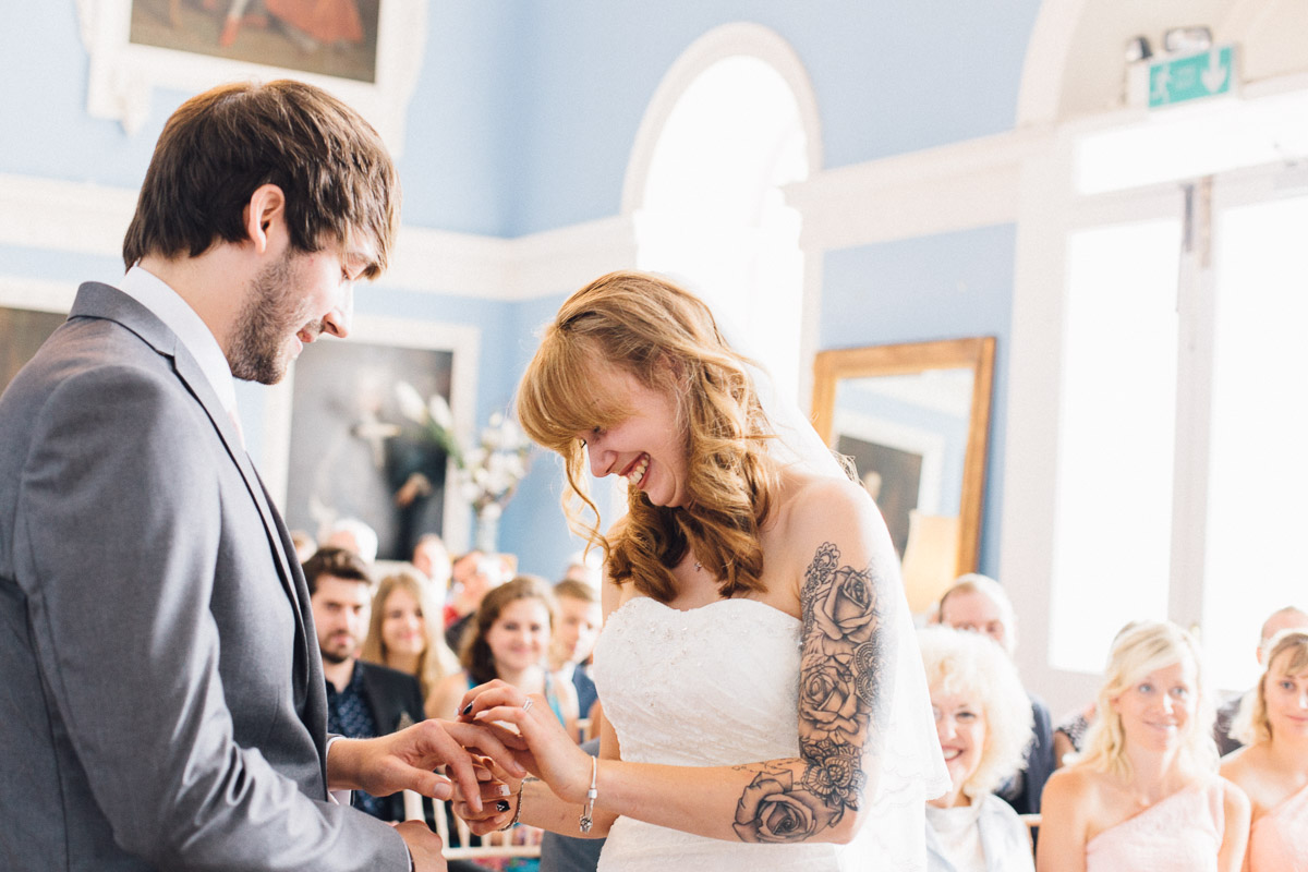 Bride Laughing Whilst putting Ring on Grooms Finger