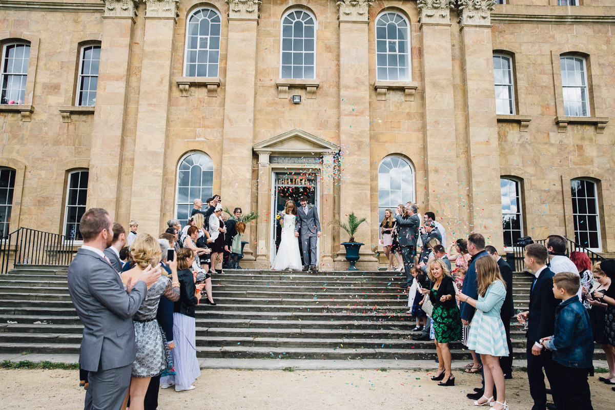 Guests Throw Confetti over couple on Steps at Kings Weston House