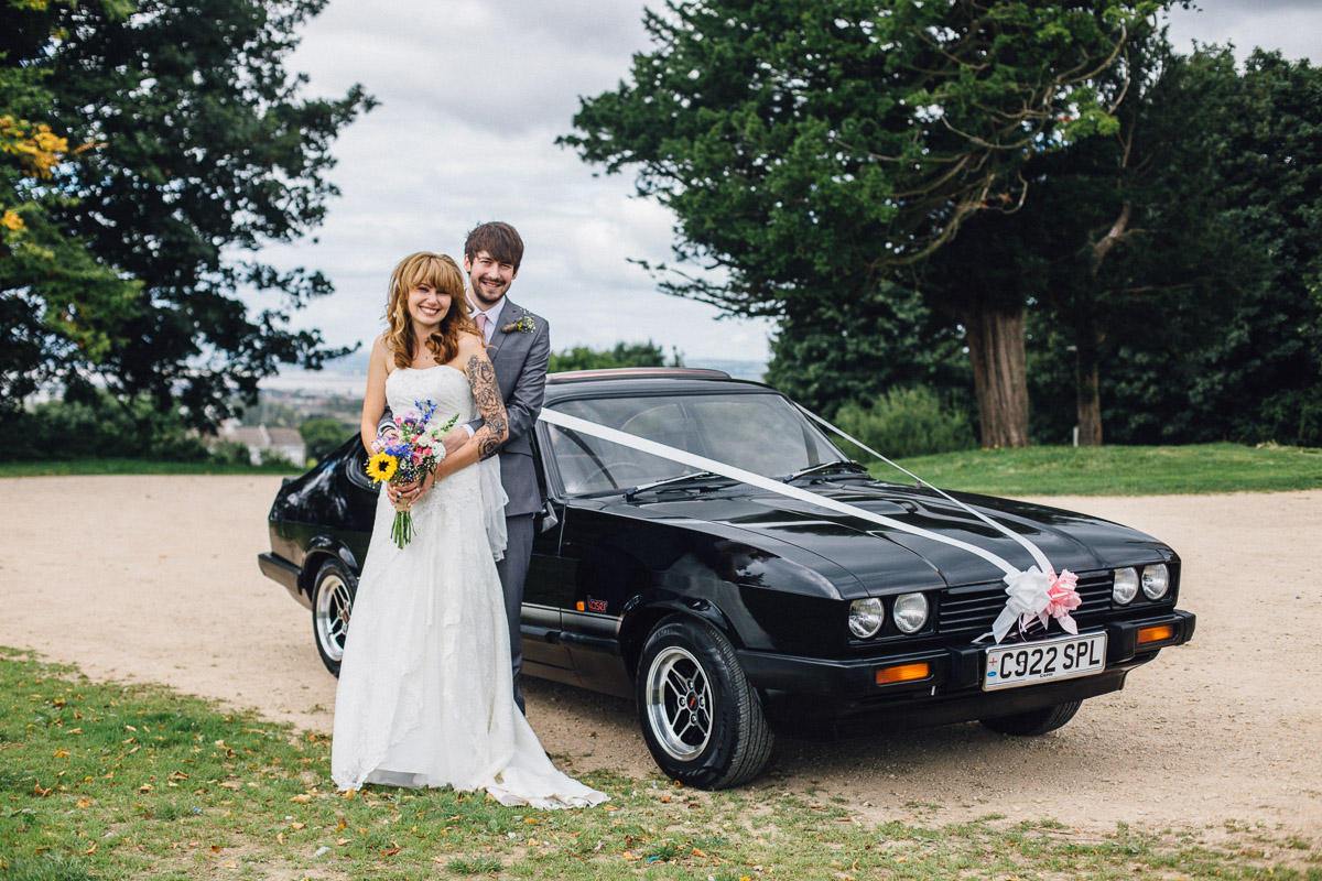 Couple Pose by Alternative Wedding Car outside Kings Weston House