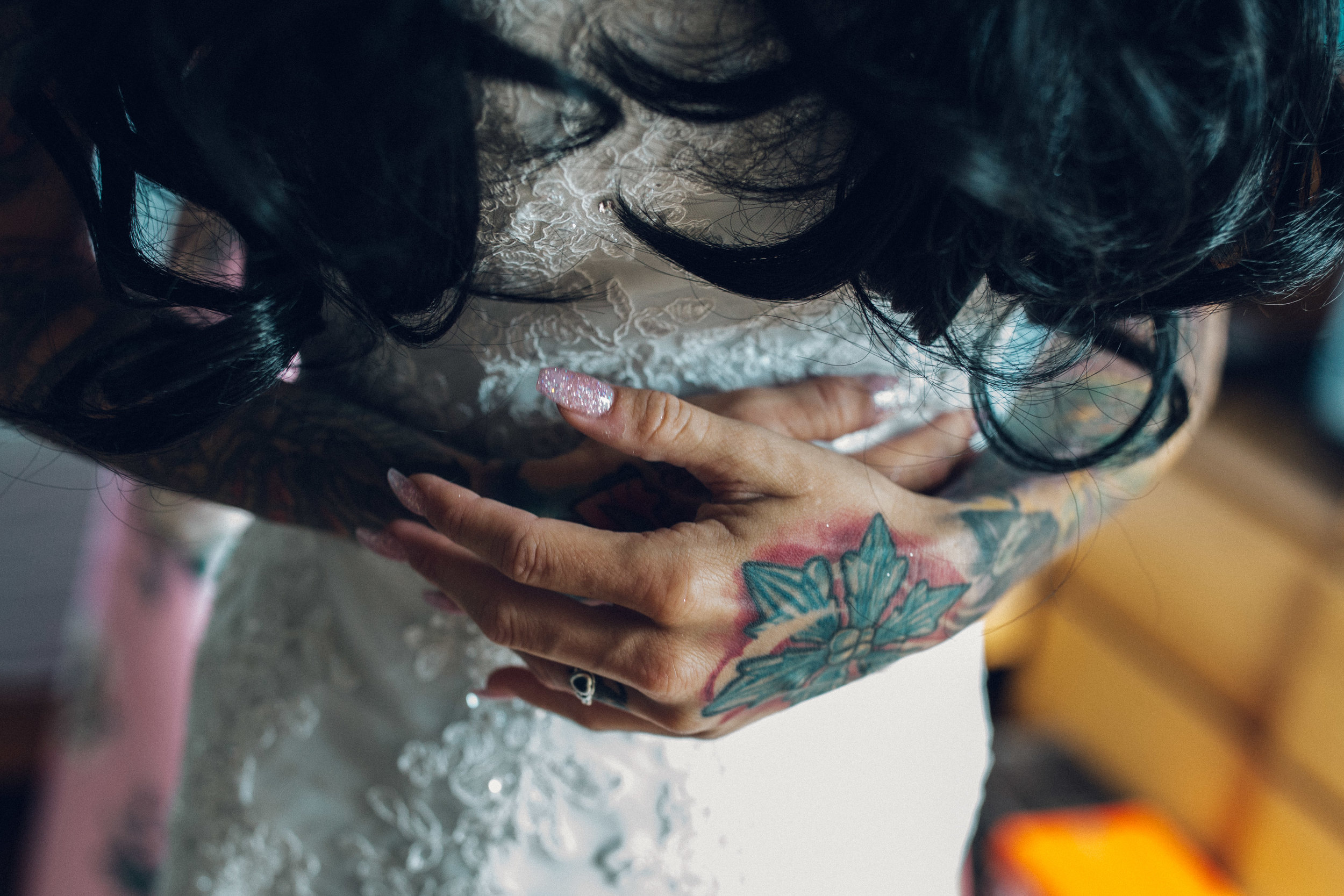Heavily tattooed bride putting dress on 