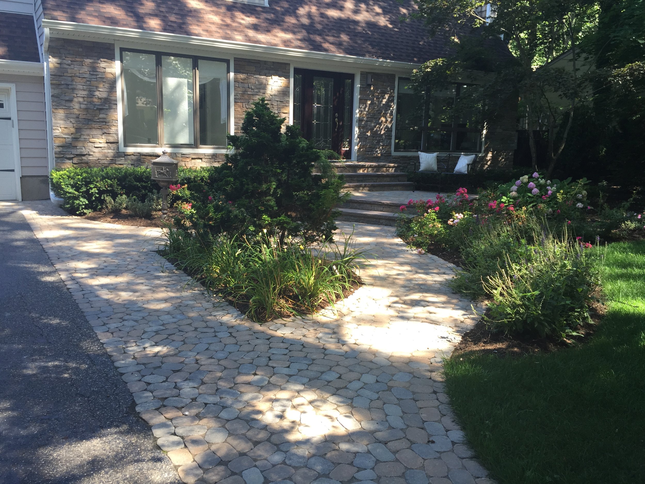 Landscape design with paved walkway in Long Island, NY