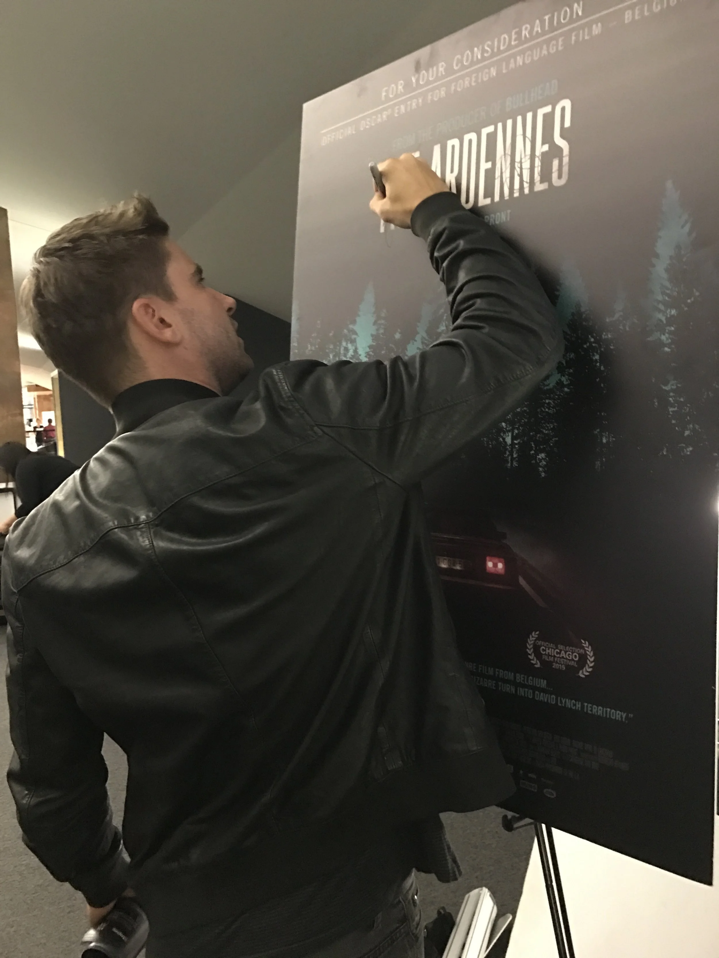  Kevin Janssens, lead actor in THE ARDENNES, signs a poster at The Wrap screening of the film - October 19, 2016. &nbsp; 