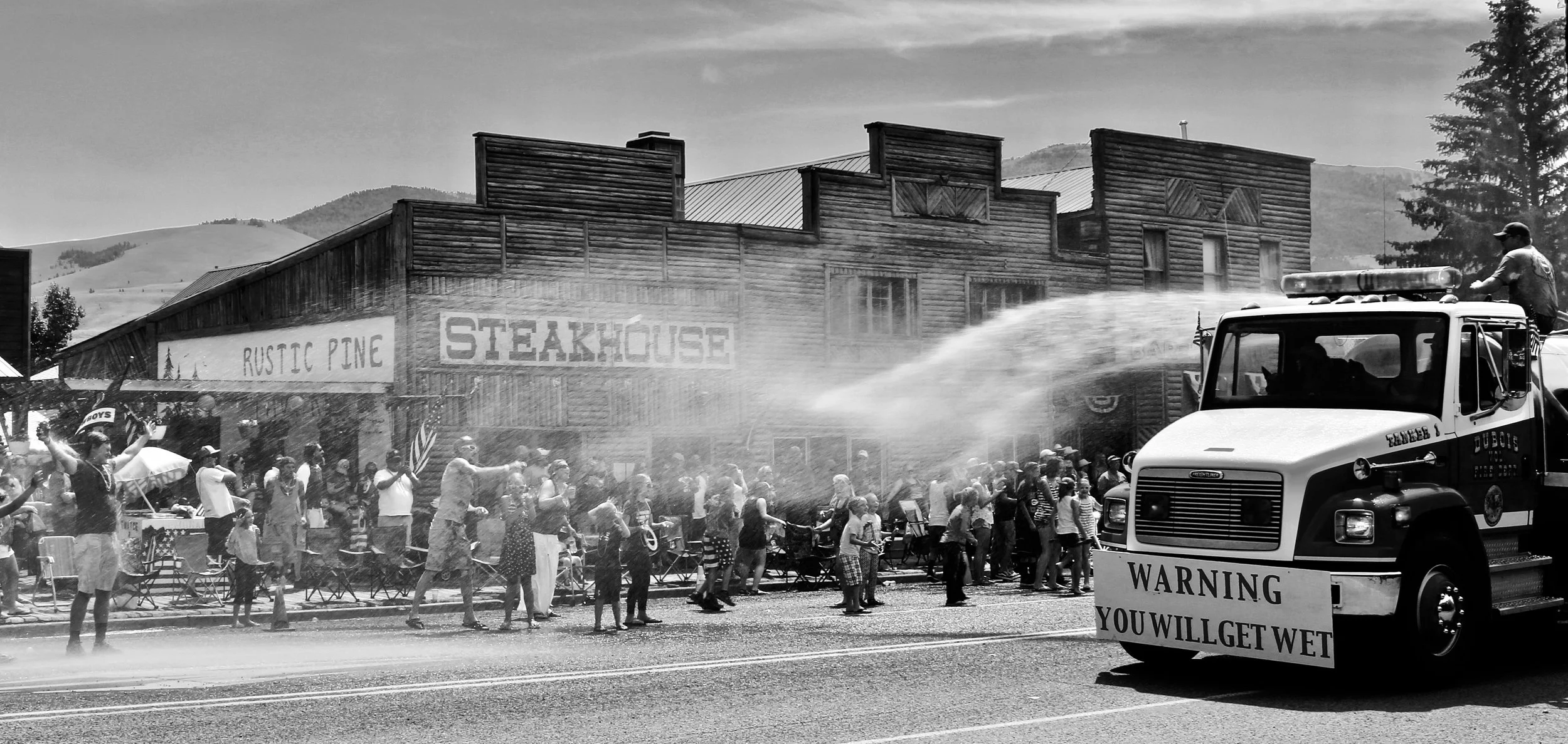 The town's firetruck sprays down the residents on a sweltering July day