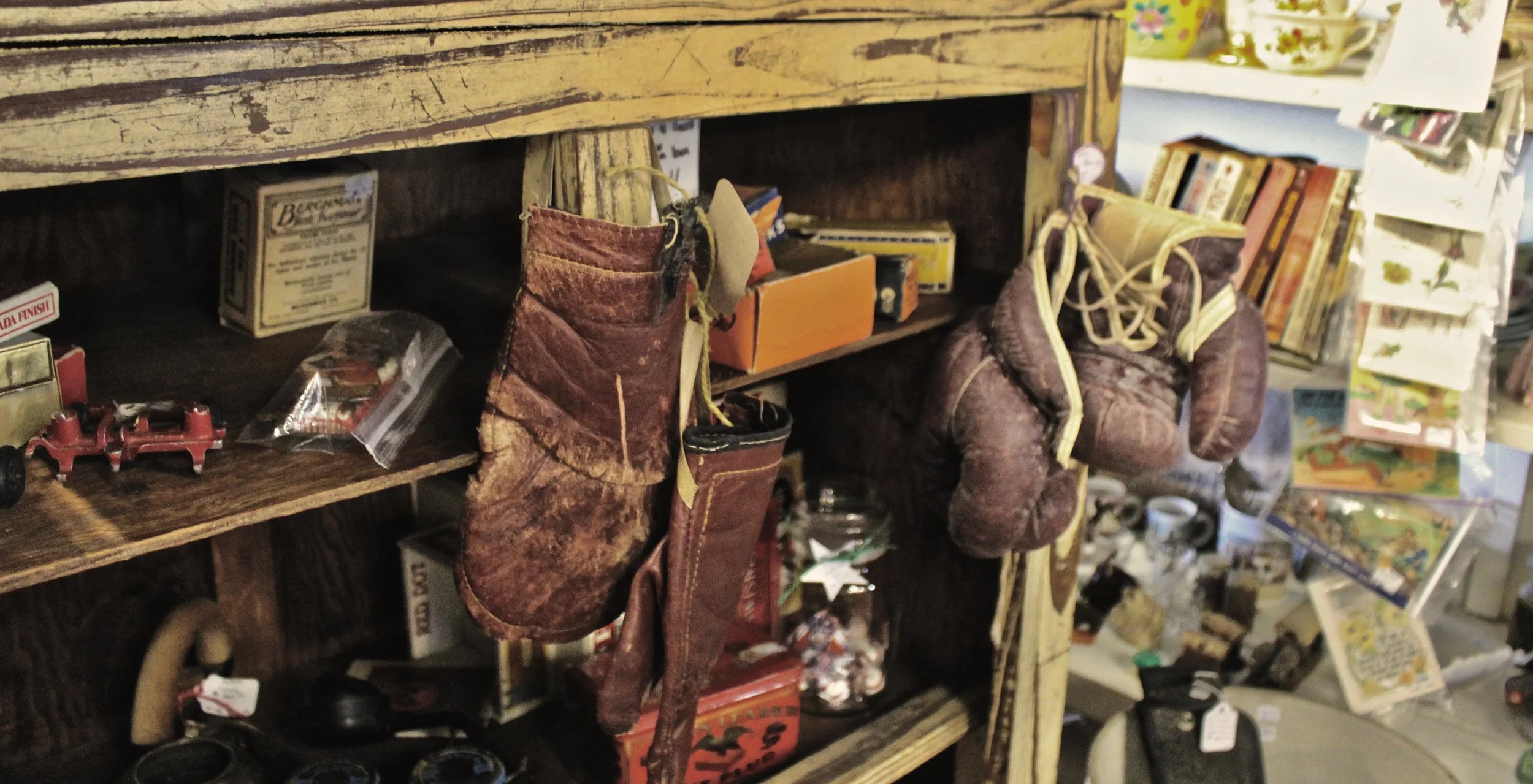 Worn boxing gloves hang as antiques from the cabinet